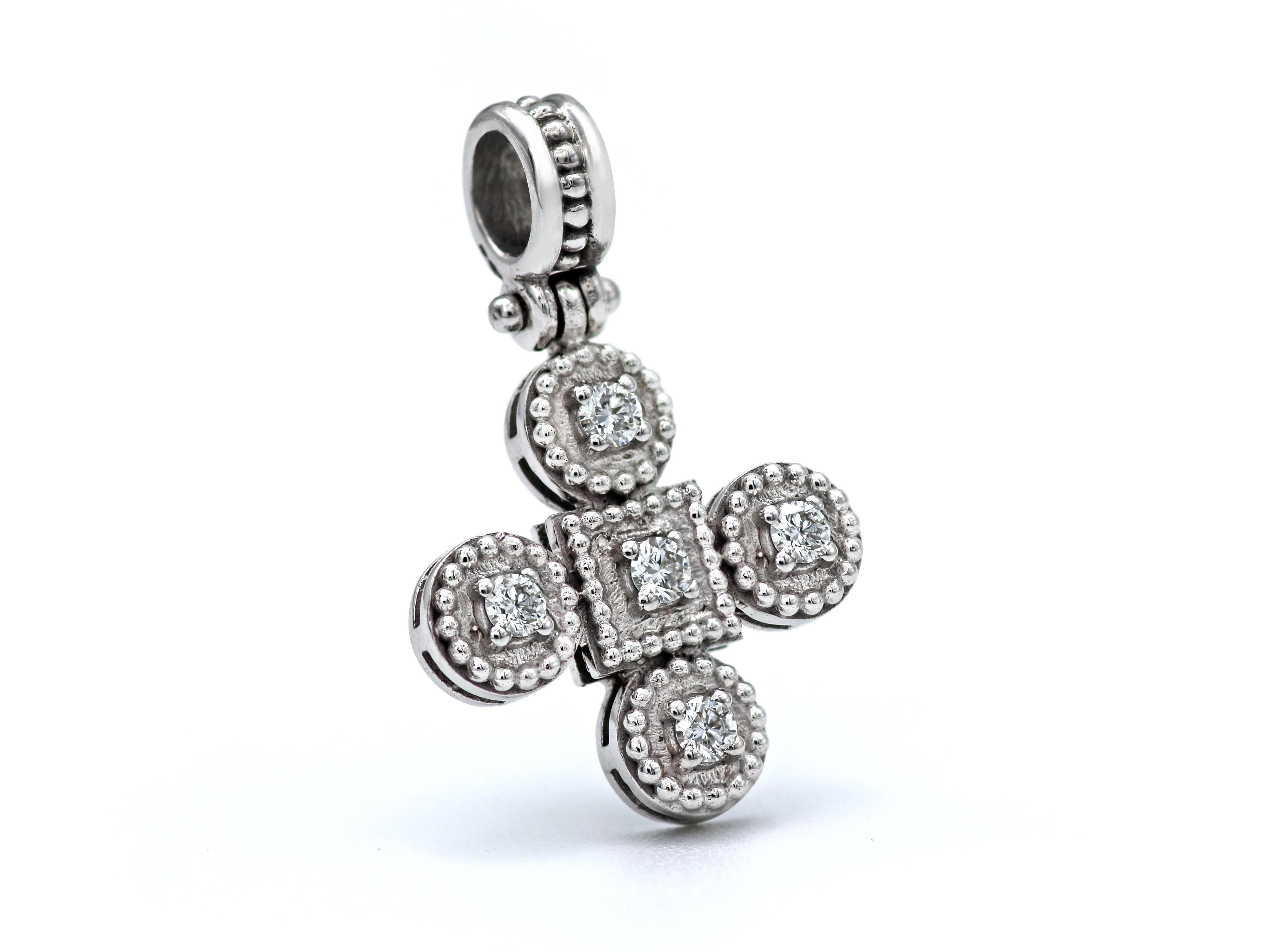 18k white gold cross of the balance collection with neoclassical inspiration work of granulations and a beautiful setting of four 0.20 carats brilliant cut diamonds. A very tasteful piece with a strong thick bezel that will make you wear it