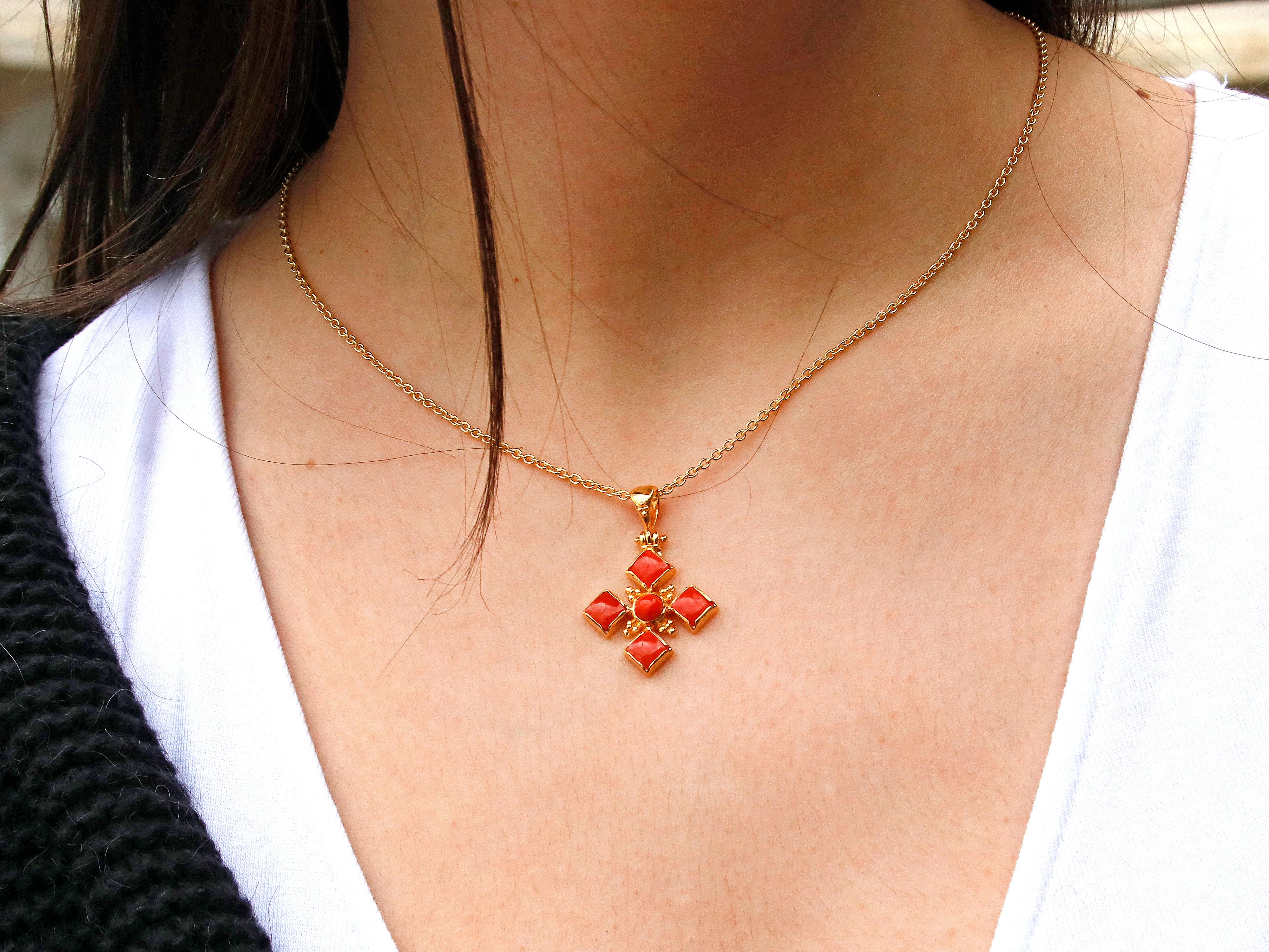 18k gold classic cross completely handmade with coral and granulation decoration. The cross is adorned with coral, which adds a pop of color to the piece. Coral is a natural gemstone and it is often associated with love, passion, and protection.