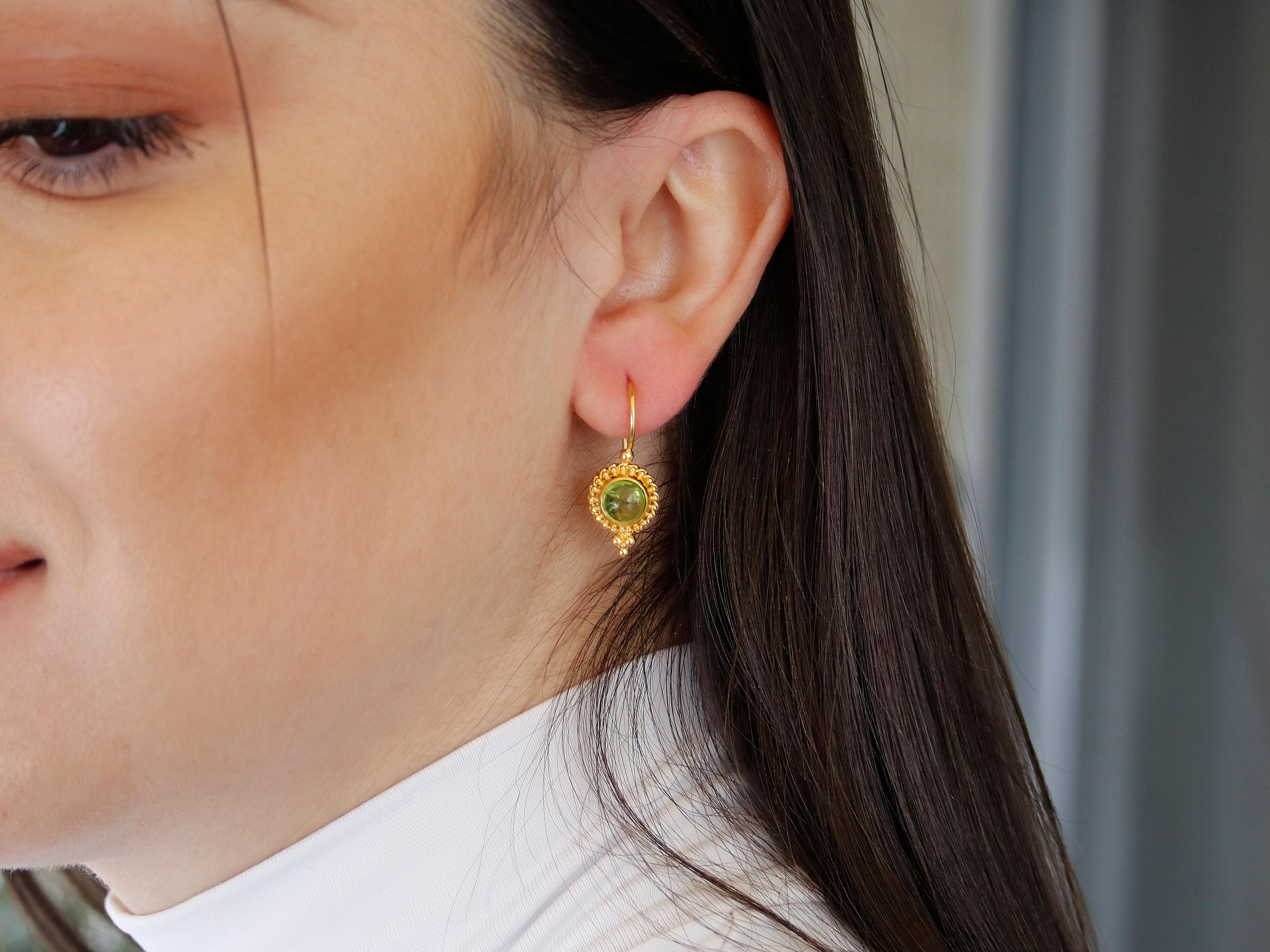 Elegant classic Greek earrings set in 18k yellow gold with beautiful peridot gemstones. The filigree and granulation decoration adds an intricate and elegant touch to the design, making them a perfect accessory for any formal occasion. The vibrant