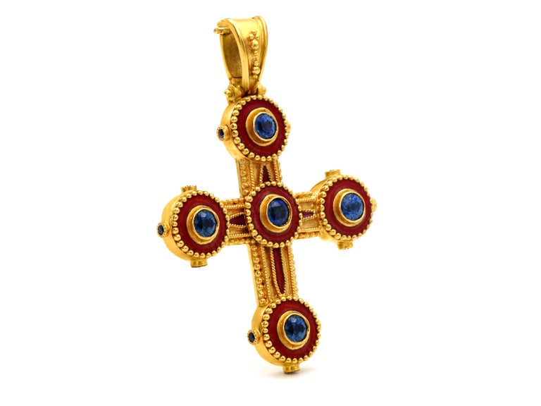 Byzantine era cross in 22 karat gold completely handmade decorated with granulation, round 0.60 carats sapphires and red enamel. On the sides of its circle our sit sideways three smaller sapphires to add authenticity to the museum reference and make