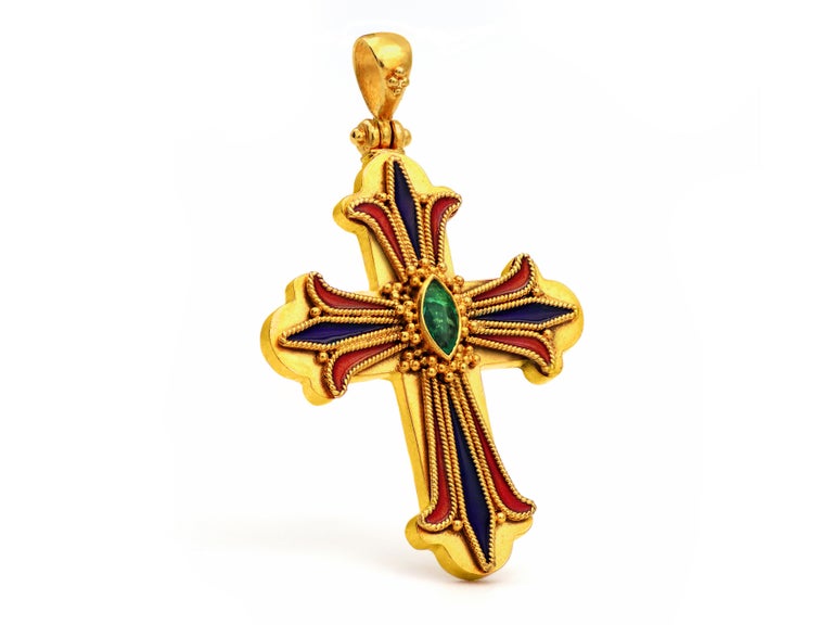 A majestic cross in 22 karat yellow gold with filigree work topped with red and blue enamel giving substantial depth and emphasis in this creation. The 0.20 carats Emerald in the middle it’s a natural marquise cut emerald surrounded with