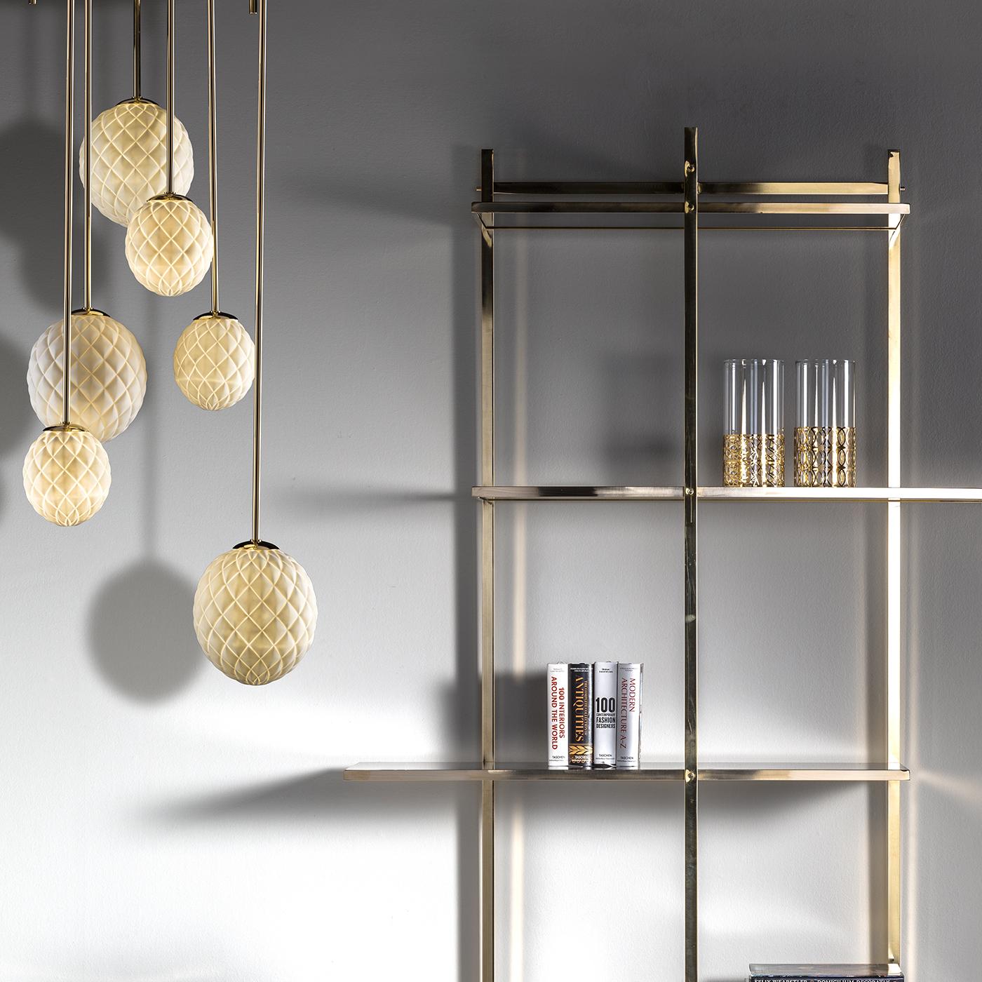 This superb bookcase is a striking decoration that adds a luxurious texture to a wall while providing ample display surface for books or collectibles. The brass structure is elegant and Minimalist, serving also as mounting for the lacquered wooden