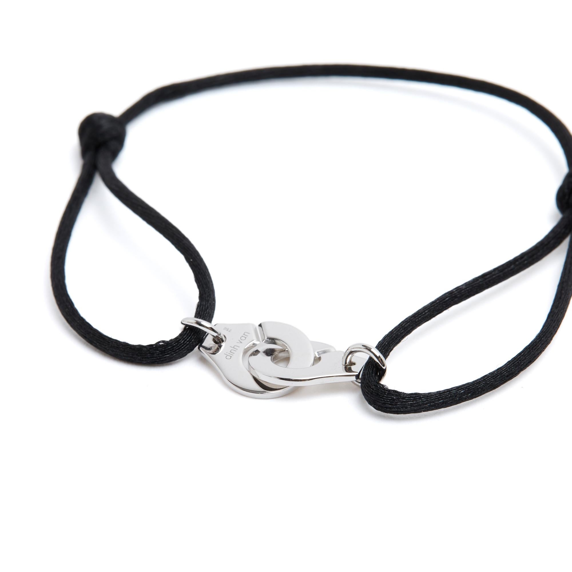 Dinh Van Menottes bracelet, Small size, in 18-carat white gold mounted on a black cord. Dimensions of the closed handcuffs (approx.) 2 x 1 cm, adjustable cord. The black cord is new (and you can have it changed for another color on request in all