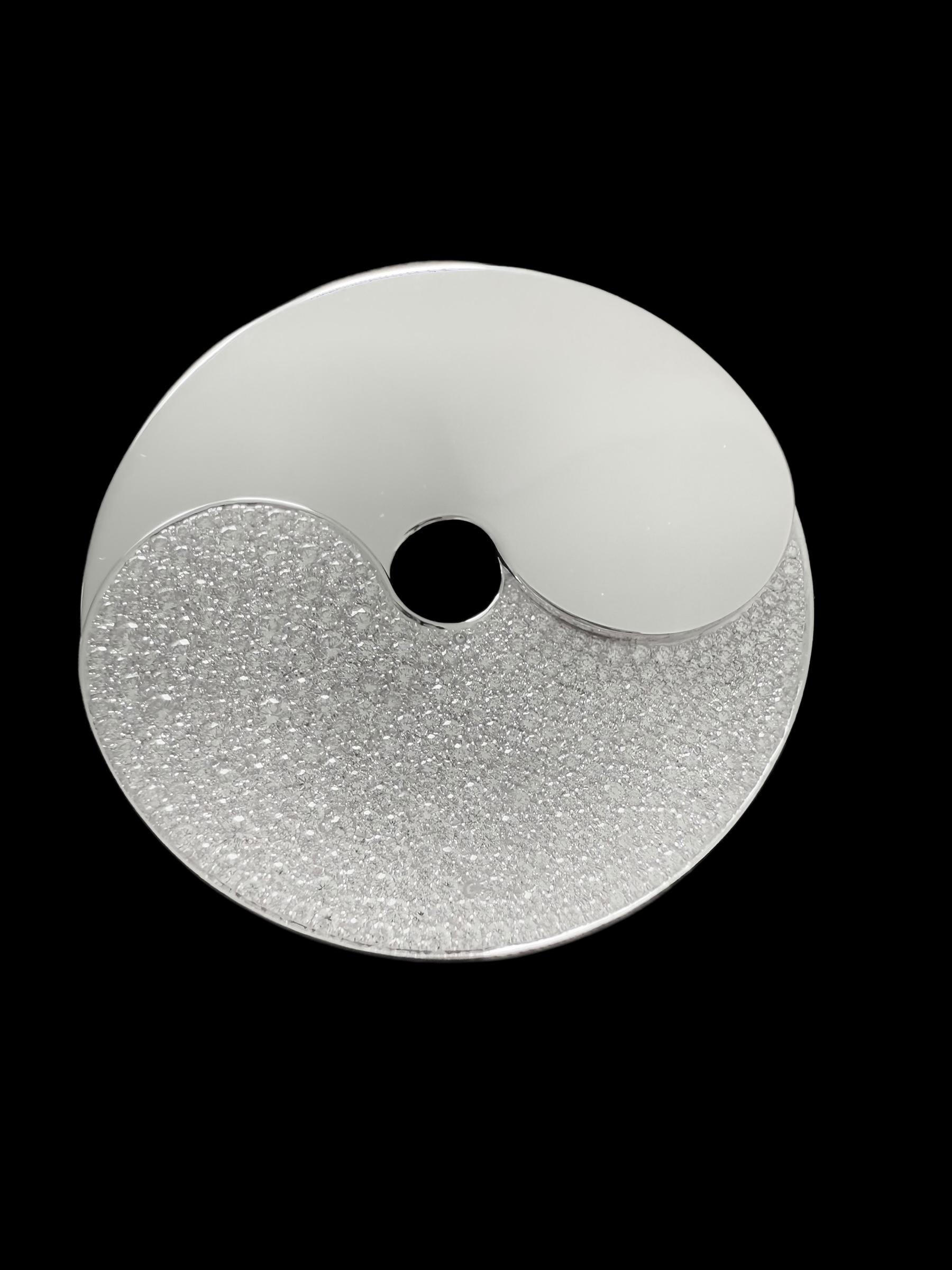 Il Ciondolo Dinh Van Double Sens è una straordinaria fusione di simbolismo ed eleganza contemporanea, realizzato in oro bianco 18 carati e impreziosito da circa 3 carati di diamanti taglio brillante incastonati a pavé di colore E-F e purezza VVS.