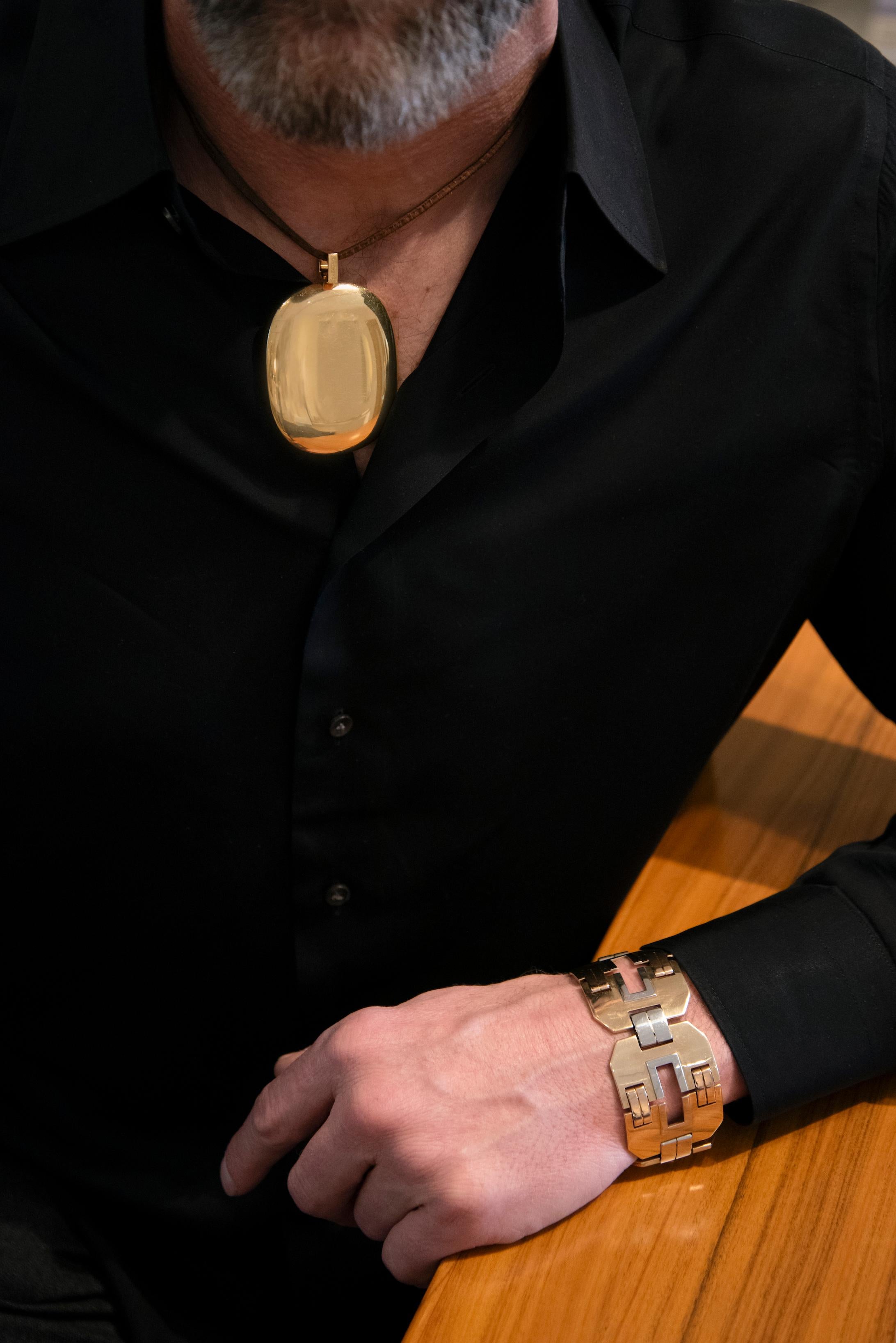 This chic, large  18-karat high polish yellow gold, cushion-shaped pendant necklace on a leather cord was designed by Dinh Van for Cartier, France, circa 1970. Rarely seen on the market, the pendant is signed Cartier, Dinh Van, and stamped with No.
