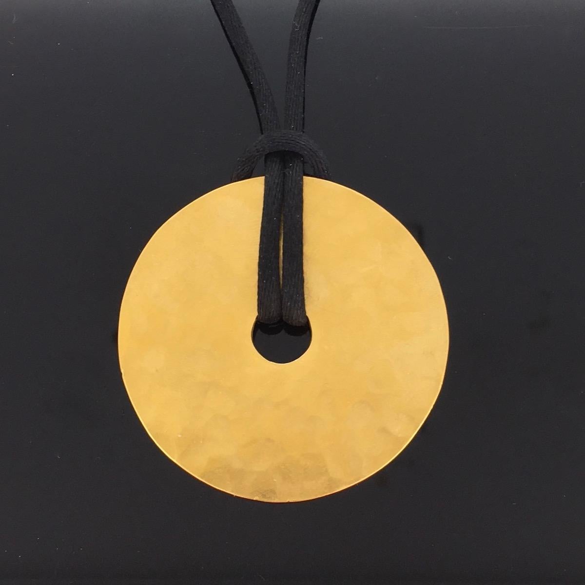 Un pendentif intemporel martelé à la main par Dinh Van. Dans l'art chinois ancien:: les disques Pi:: souvent façonnés en jade:: représentent le ciel:: l'infini et le bien-être. Le disque Pi était également utilisé comme emblème d'autorité par les