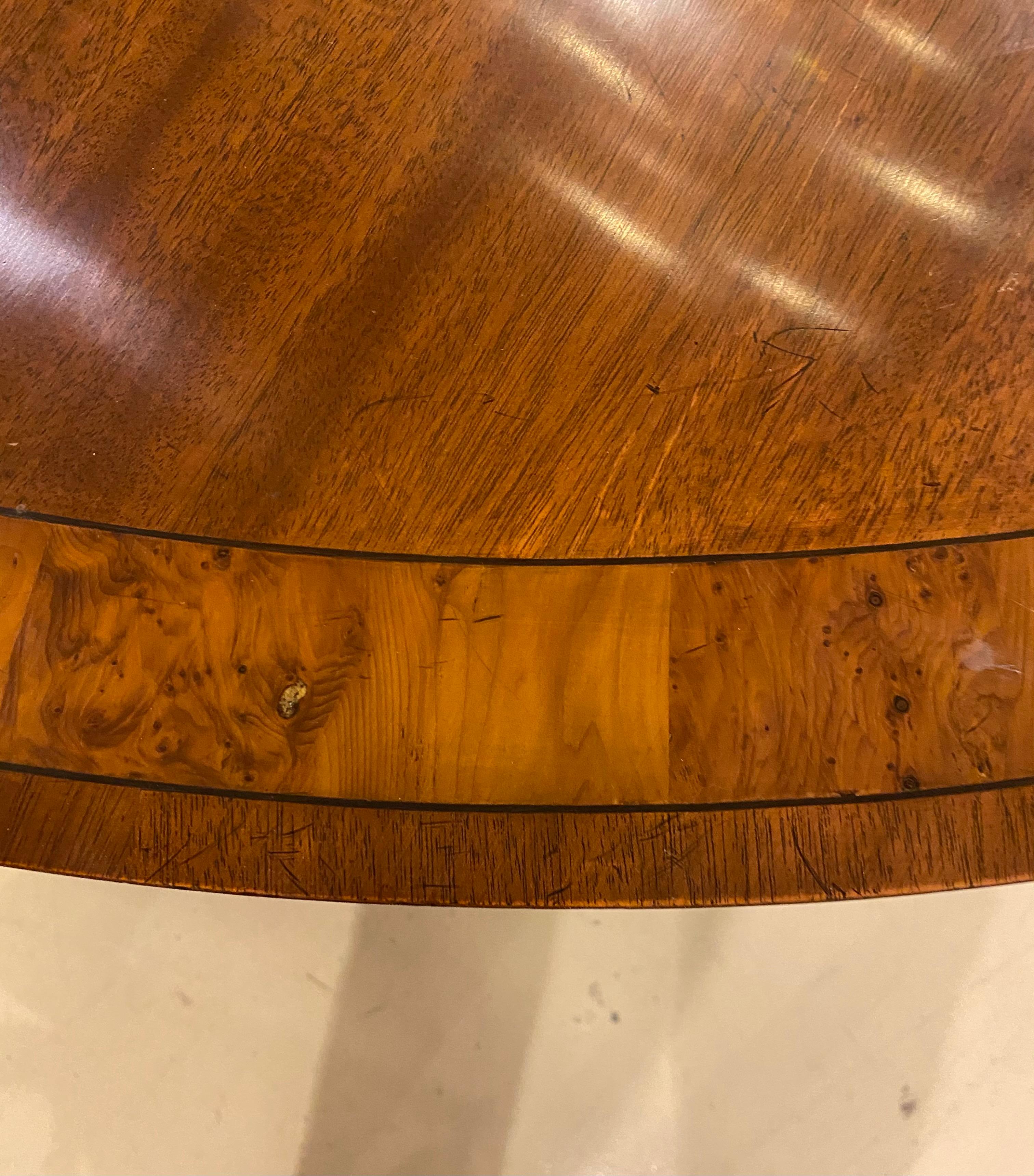 Round dining or centre table lovely mahogany graining with a yew band and an ebony inlay on a mahogany pedestal with brass fittings.