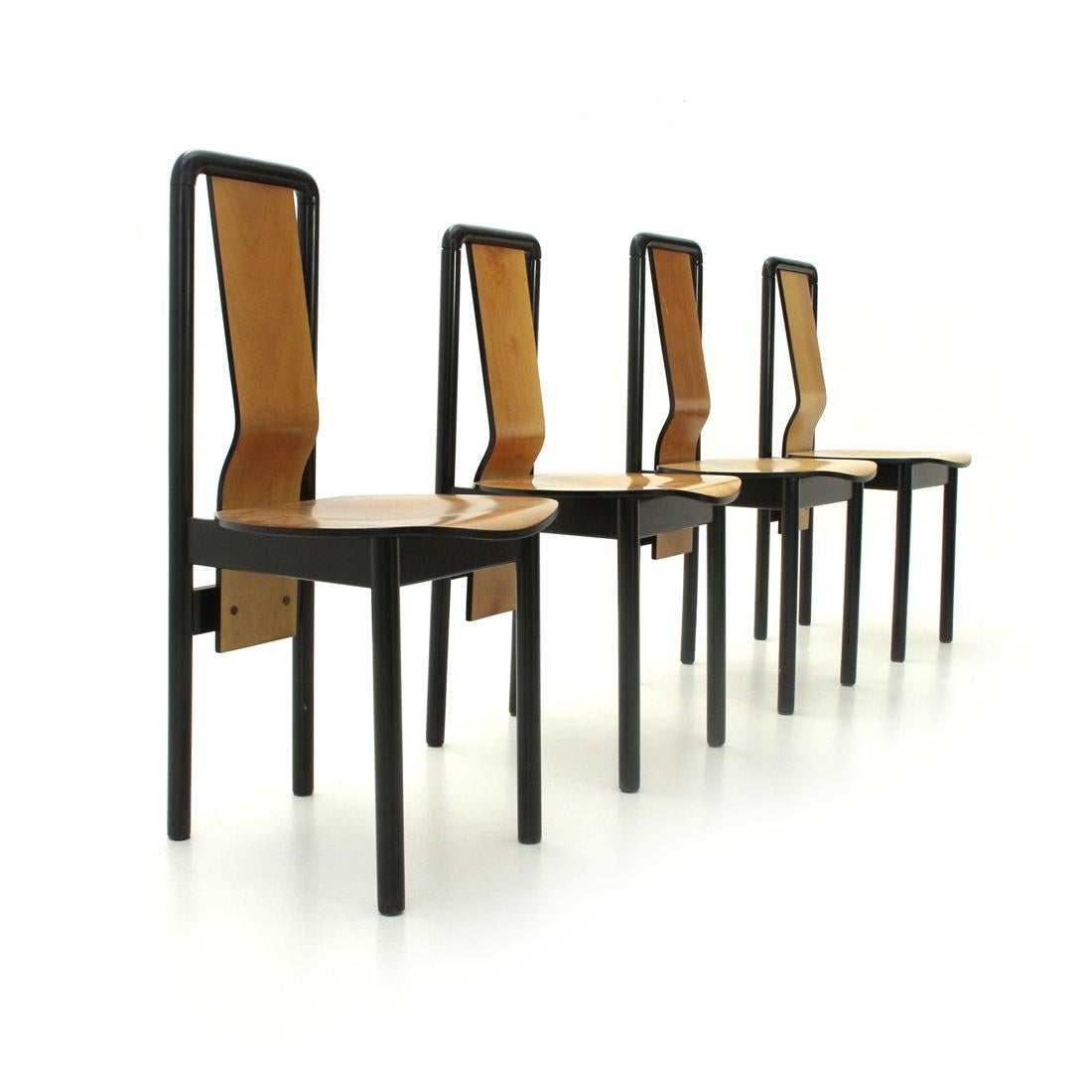 Set of four chairs, designed and produced by Pierre Cardin.
Black painted metal structure with curved plywood seat and back.
Structure in good condition, some signs due to normal use over time. One chair has the back lower than the
