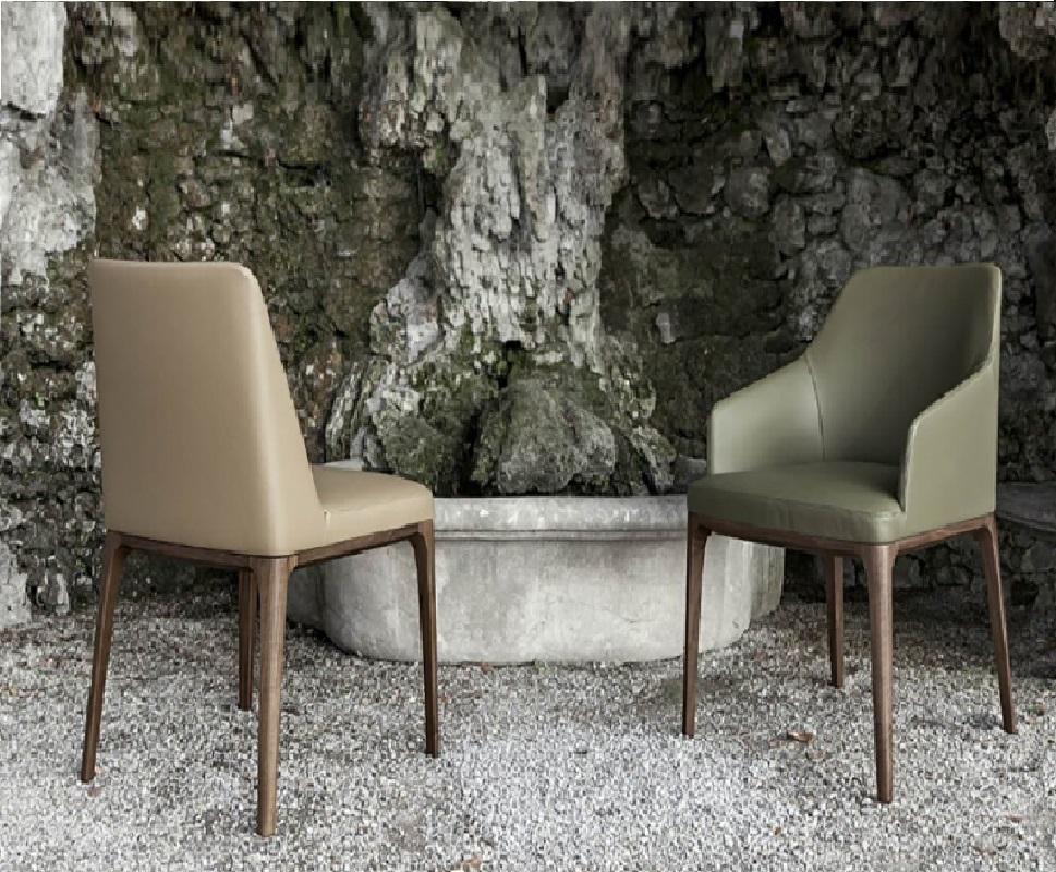 This versatile and simple chair adapts effortlessly to any living space.  It features solid ash or national walnut legs, a Polimex shell covered with polyurethane rubber and polyester fiber lining, and a choice of leather or fabric upholstery in
