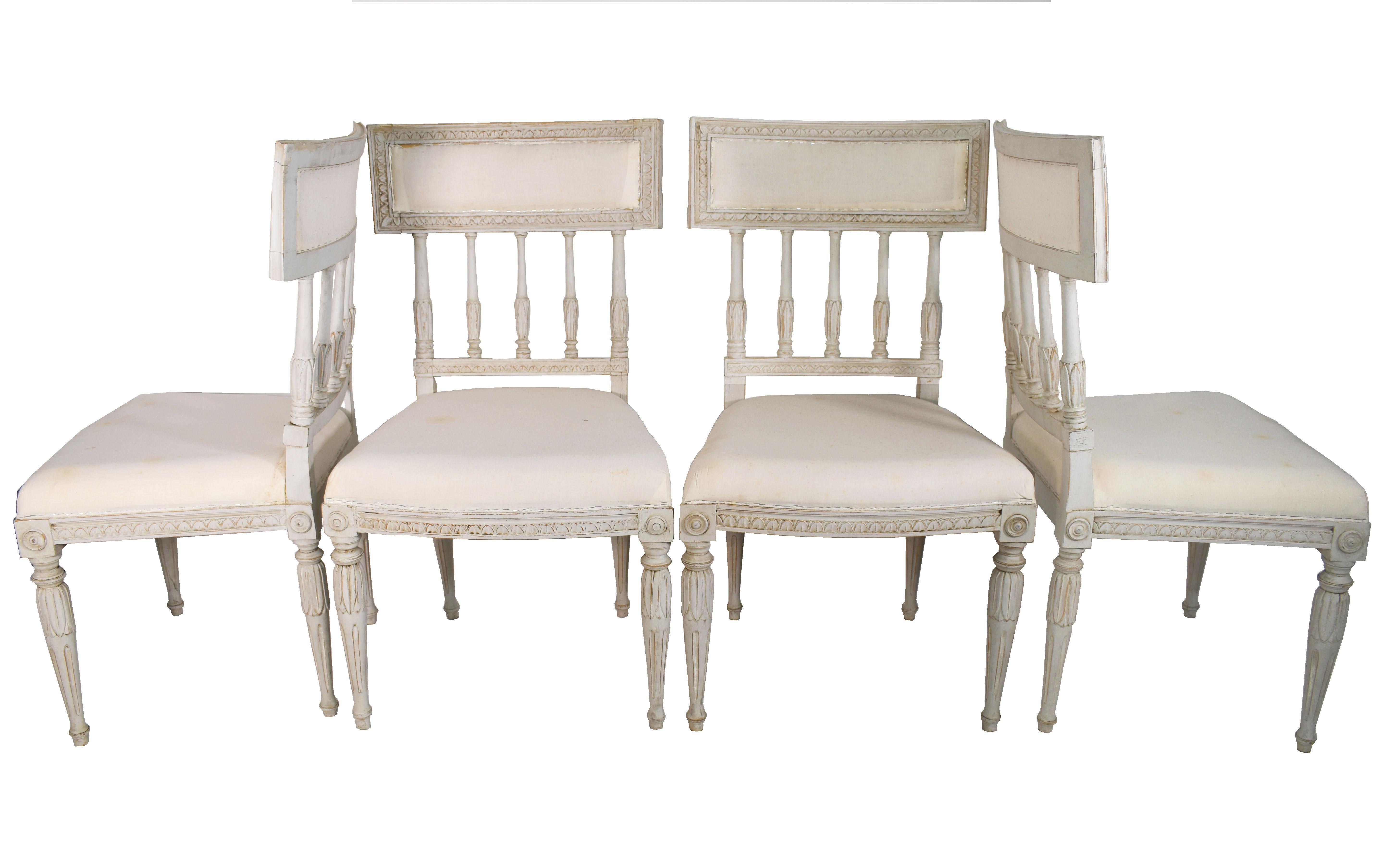 Classic set of four (4) vintage dining chairs with straight lines and hand carved details on front, back, and chair legs. Wood color grayish white with muslin seat.