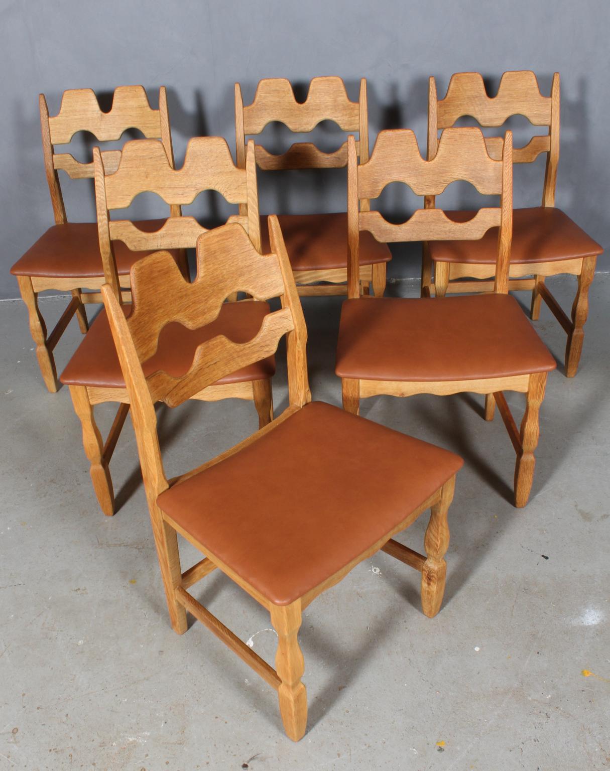 Set of striking dining chairs by Henning Kjærnulf, made of oak and new upholstered with tan aniline leather. 

Refreshing design with bold Baroque coming together nicely with Mid-Century Modernism.

Model: Razorblade

Made by EG møbler in the