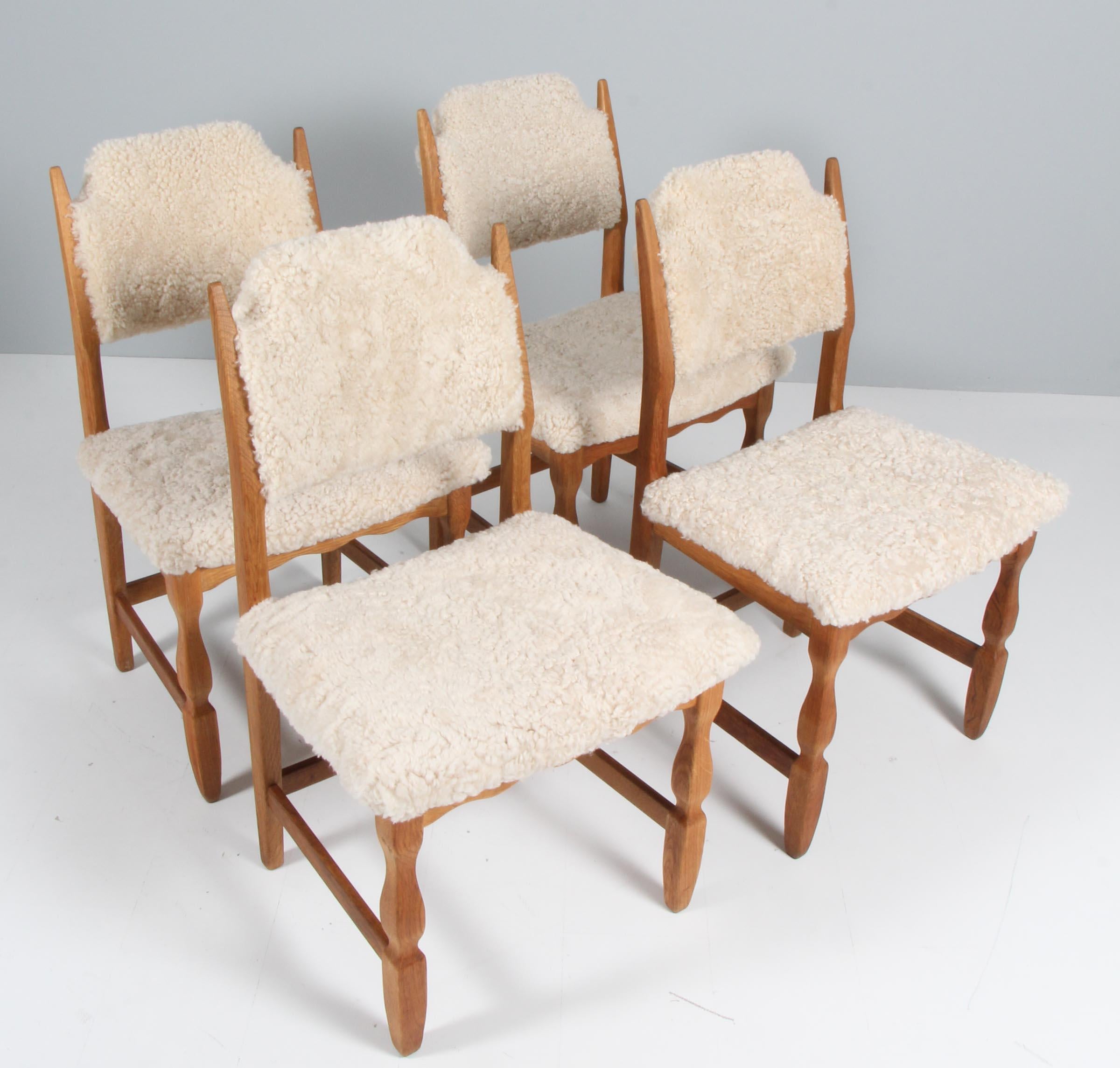 Ensemble de chaises de salle à manger de Henning Kjærnulf, en chêne et recouvertes de peau d'agneau.

Un design rafraîchissant où le baroque audacieux se marie bien avec le modernisme du milieu du siècle.

Modèle : Lame de rasoir

Fabriqué par EG