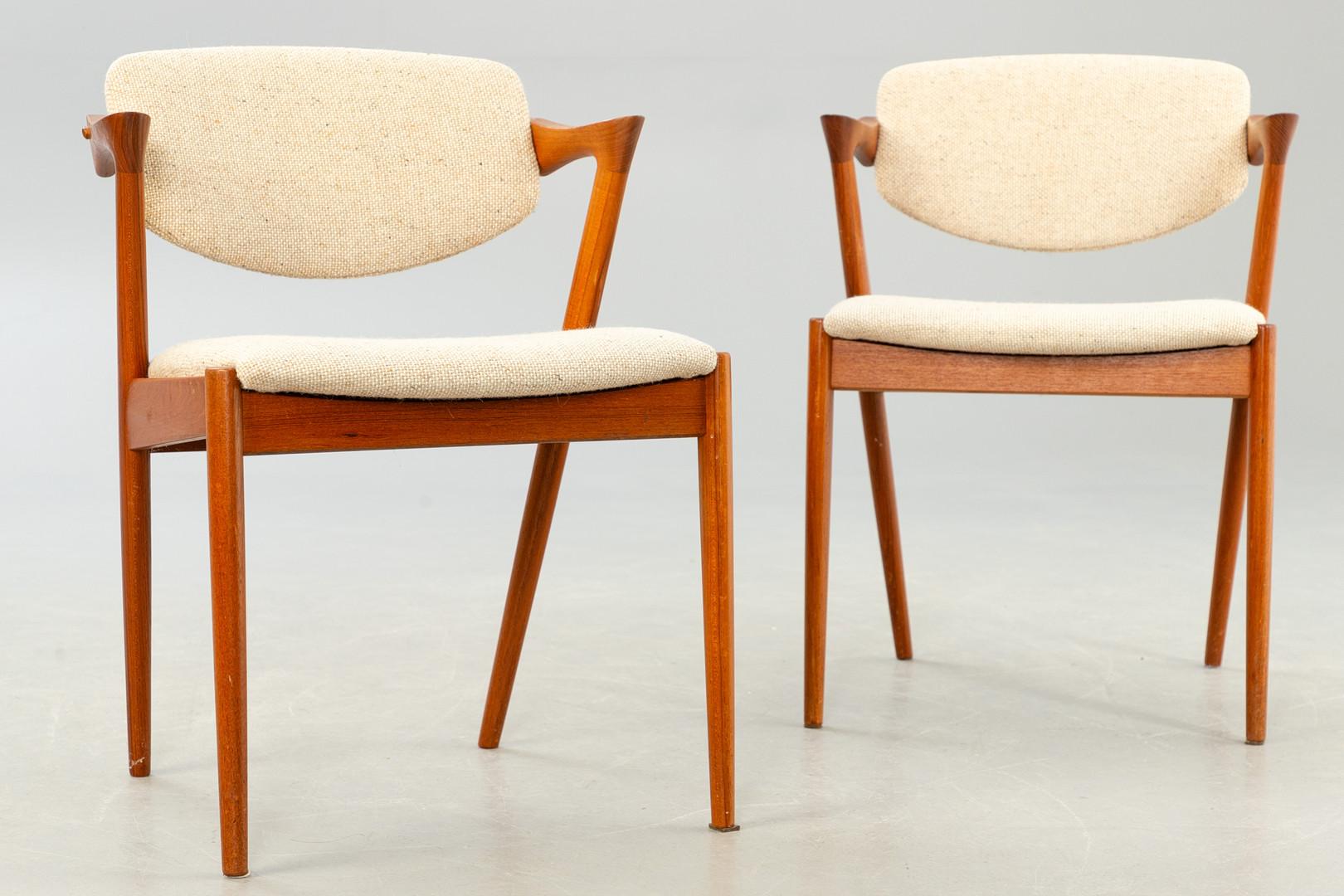 Dining chairs, model 42, designed by Kai Kristiansen and manufactured in Denmark by Schou Andersen Møbelfabrik. The chairs are made from solid teak, featuring tapered legs, curved armrests and wool upholstery. Good vintage condition. Price per