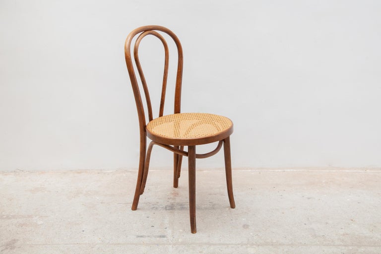 Dining chairs set of four. The bentwood of this chairs has a beautiful, warm brown colour and is crafted with an impressive eye for detail. The chairs have a caned seat which gives the chairs their elegant touch. The chairs are labeled underneath