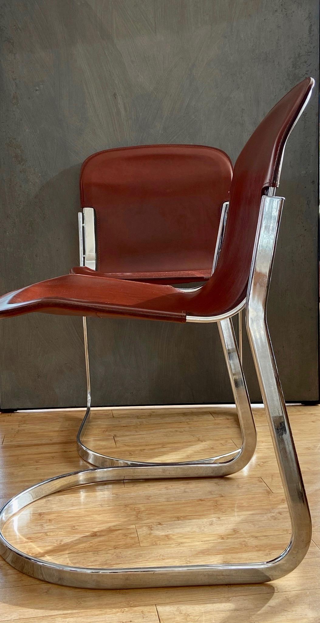 Set of two dining chairs designed by Willy Rizzo for Cidue. Elegant chrome frame and original cognac saddle leather.