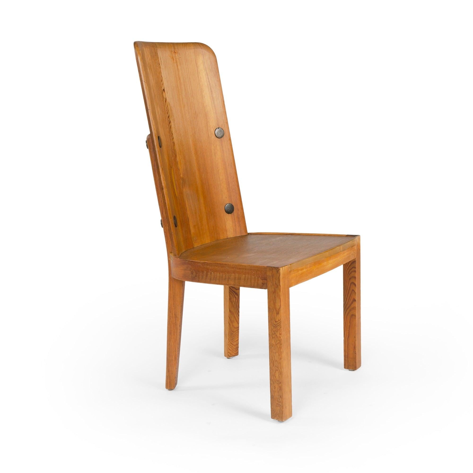 An uncommon set of four (4) solid pine 'Lovo' dining chairs with black iron rivets and floating bouclÃ© cushions.