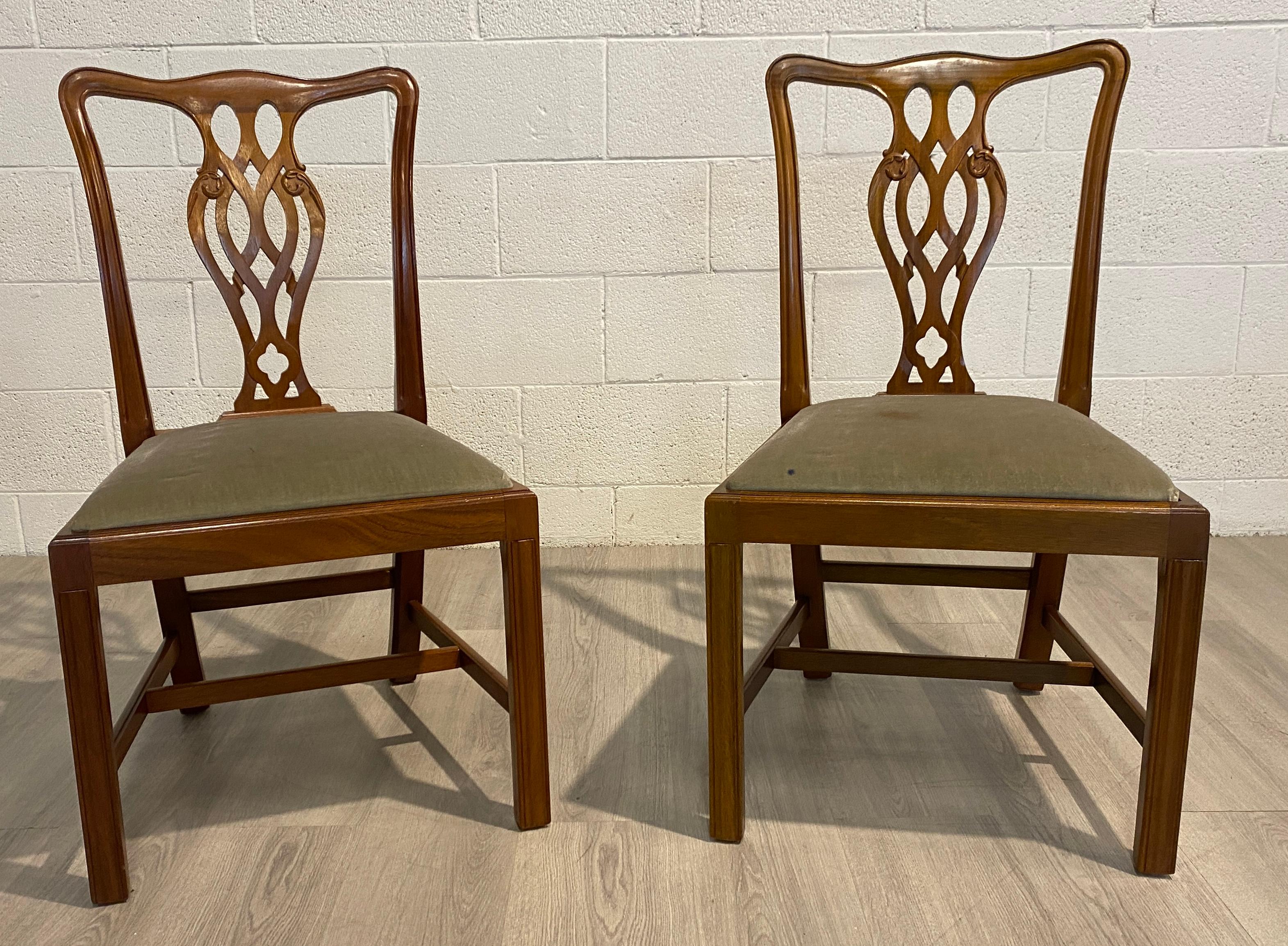 A solid pair Georgian style mahogany dining chairs made in England. The Chippendale style chairs are without arms. Upholstered in their original mint green cover with the pop out seats they can be easily renewed.