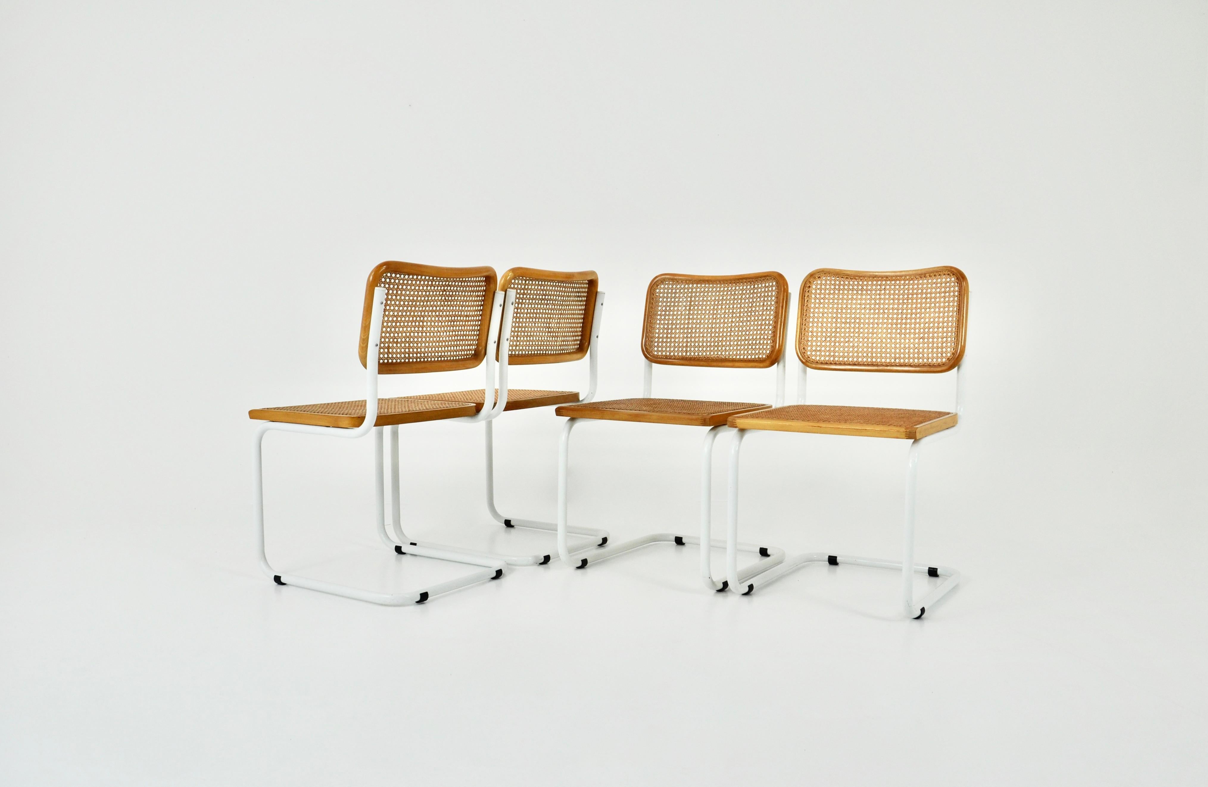 Set of 4 chairs in white metal, wood and cane. Wear due to time and age of the chairs. 
Measure: seat height: 45 cm.
Usure due au temps et l'âge des chaises.