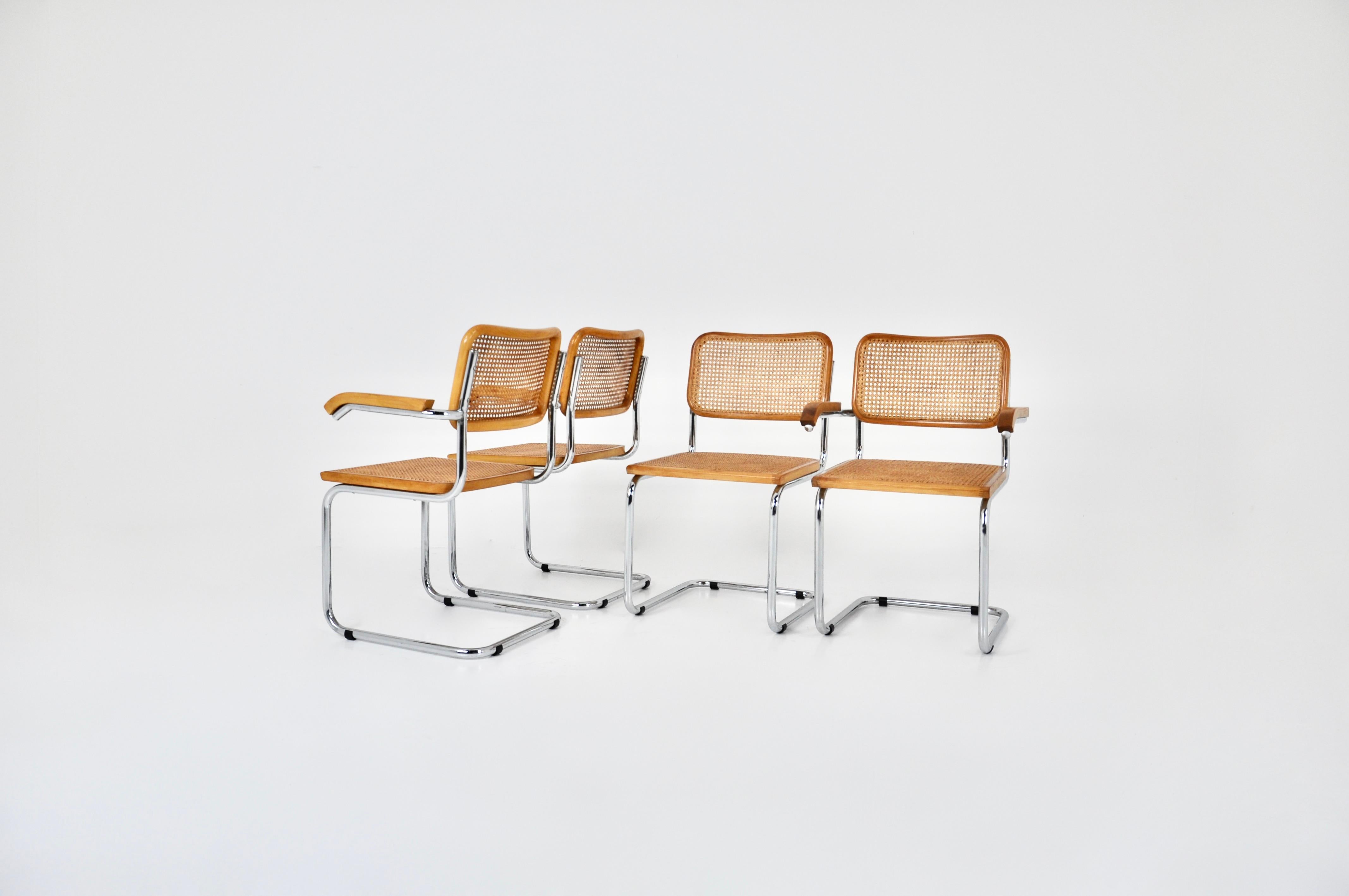 Set of 4 chairs in metal, wood and rattan. 2 with arms and 2 without arms. 
Dimensions: seat height: 45 cm. Width with armrests :58  cm 
Wear due to time and age of the chairs. 


