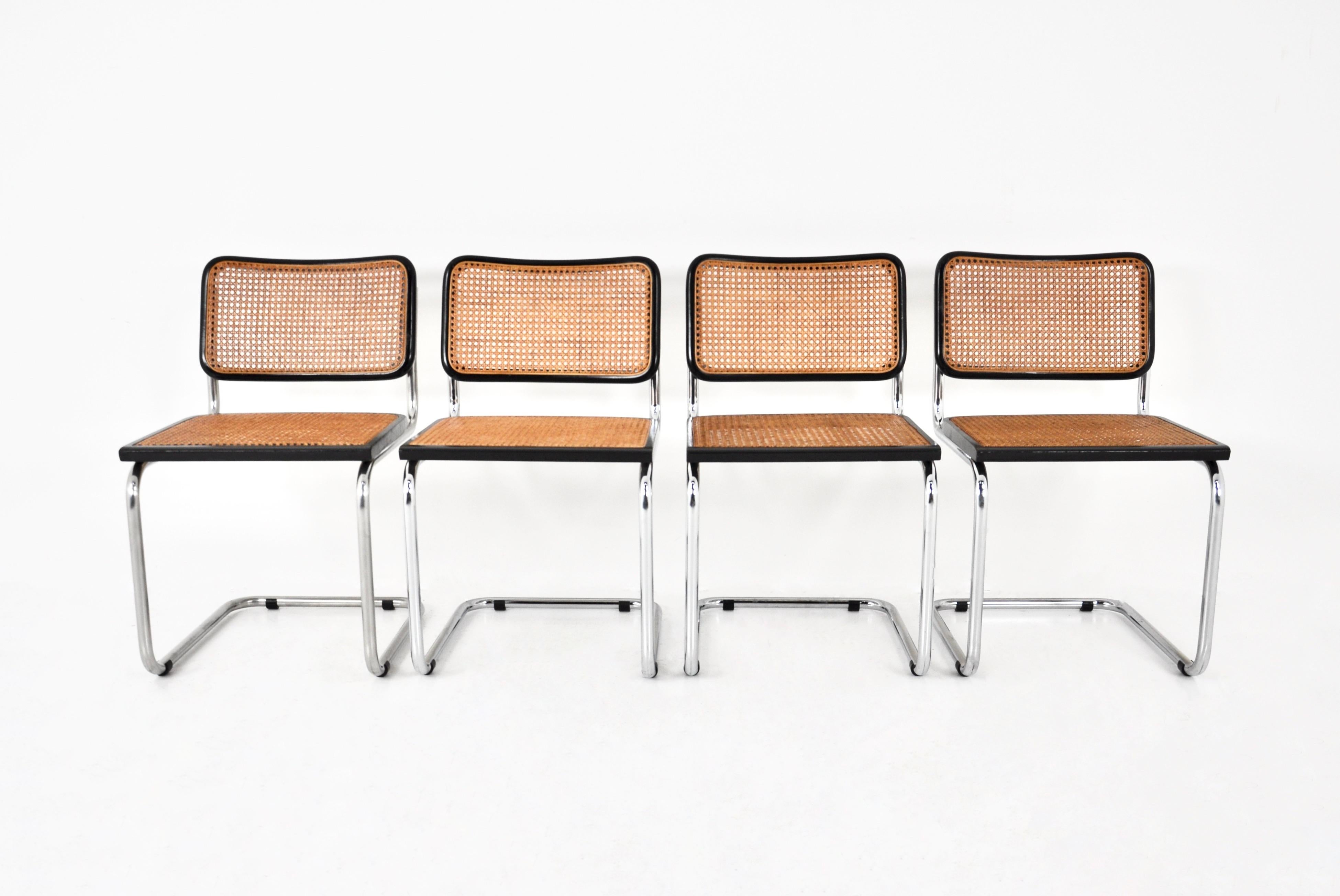 Ensemble de 4 chaises en bois, rotin et métal. Dimensions : hauteur du siège : 46 cm. Usure due au temps et à l'âge des chaises.