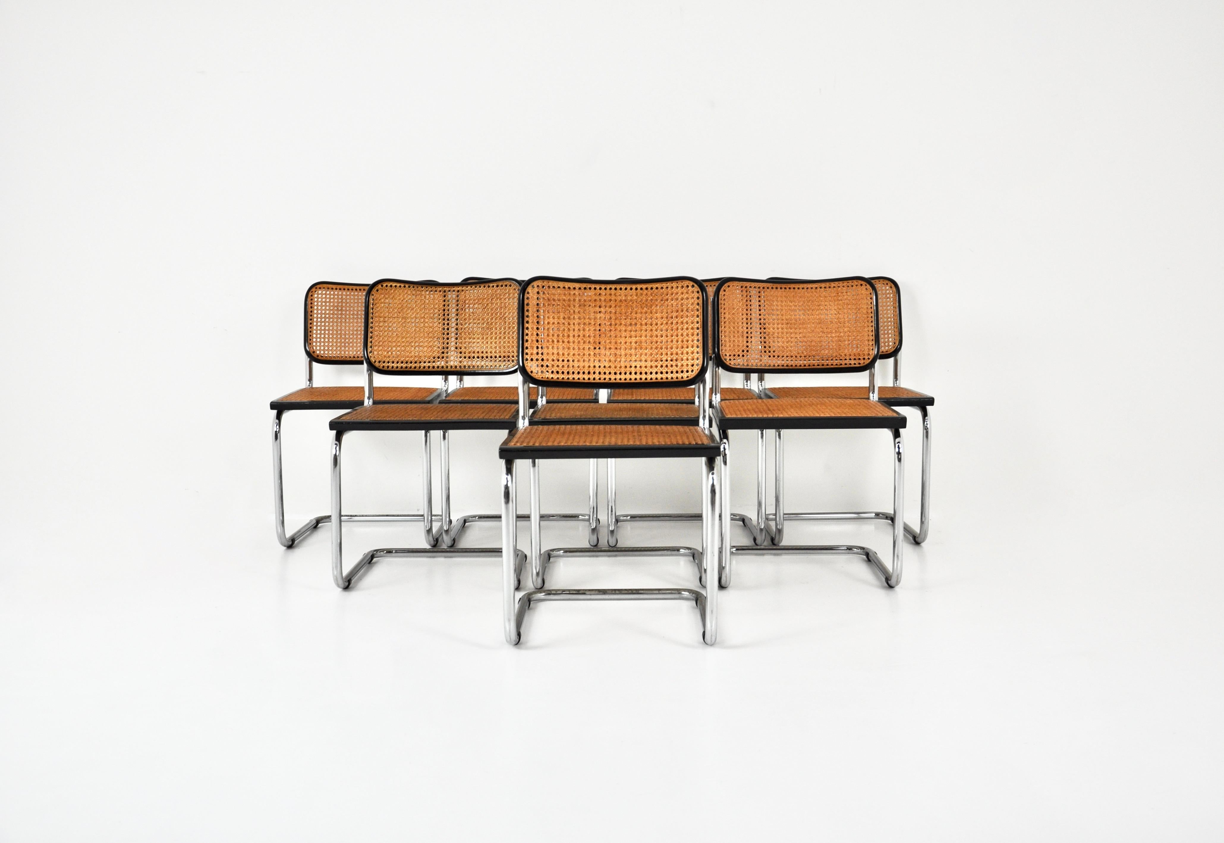 8er-Set  schwarze Stühle aus Metall, Holz und Rattan. Sitzhöhe: 46 cm. Abnutzung durch die Zeit und das Alter der Stühle. 