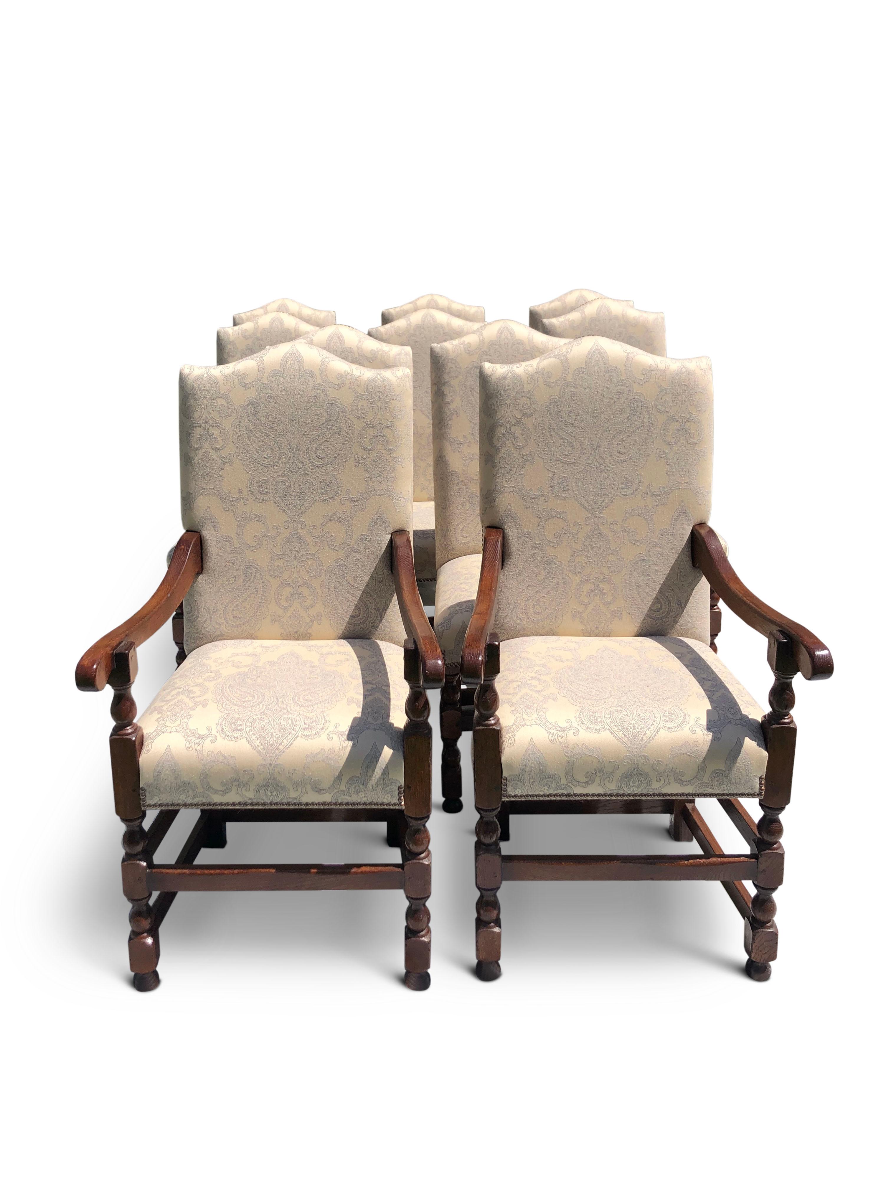 A set of 10 oak dining chairs manufactured by Garners.
Two carvers and eight chairs camel backs, turned baluster legs with stretchers upholstered in beautiful neutral stone, duck egg blue damask fabric.
  