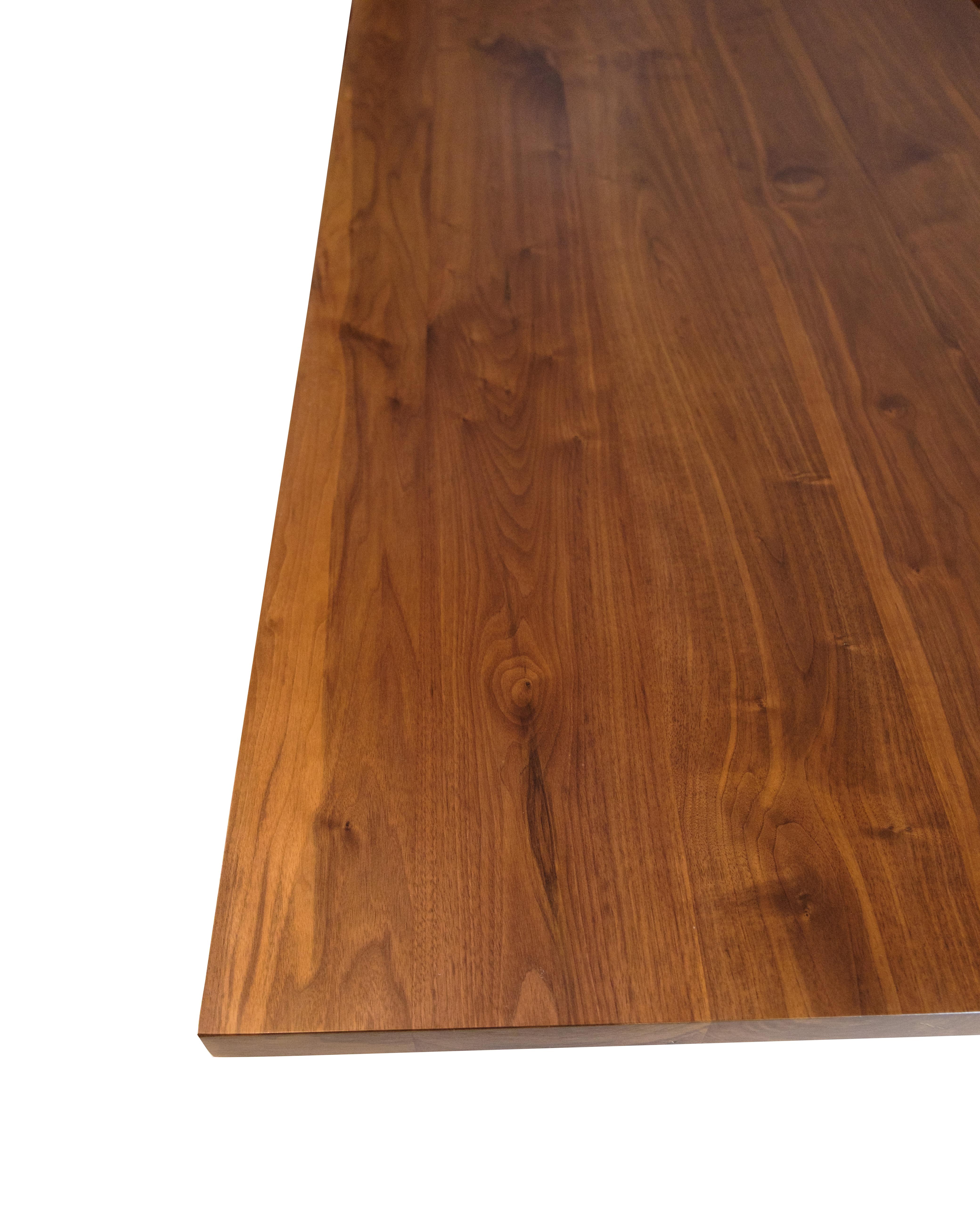 Table de salle à manger en noyer massif (séché au four) avec une surface traitée à l'huile qui met en valeur la structure naturelle du bois. La structure en métal laqué noir confère à la table un aspect moderne et robuste.

Nous fabriquons diverses