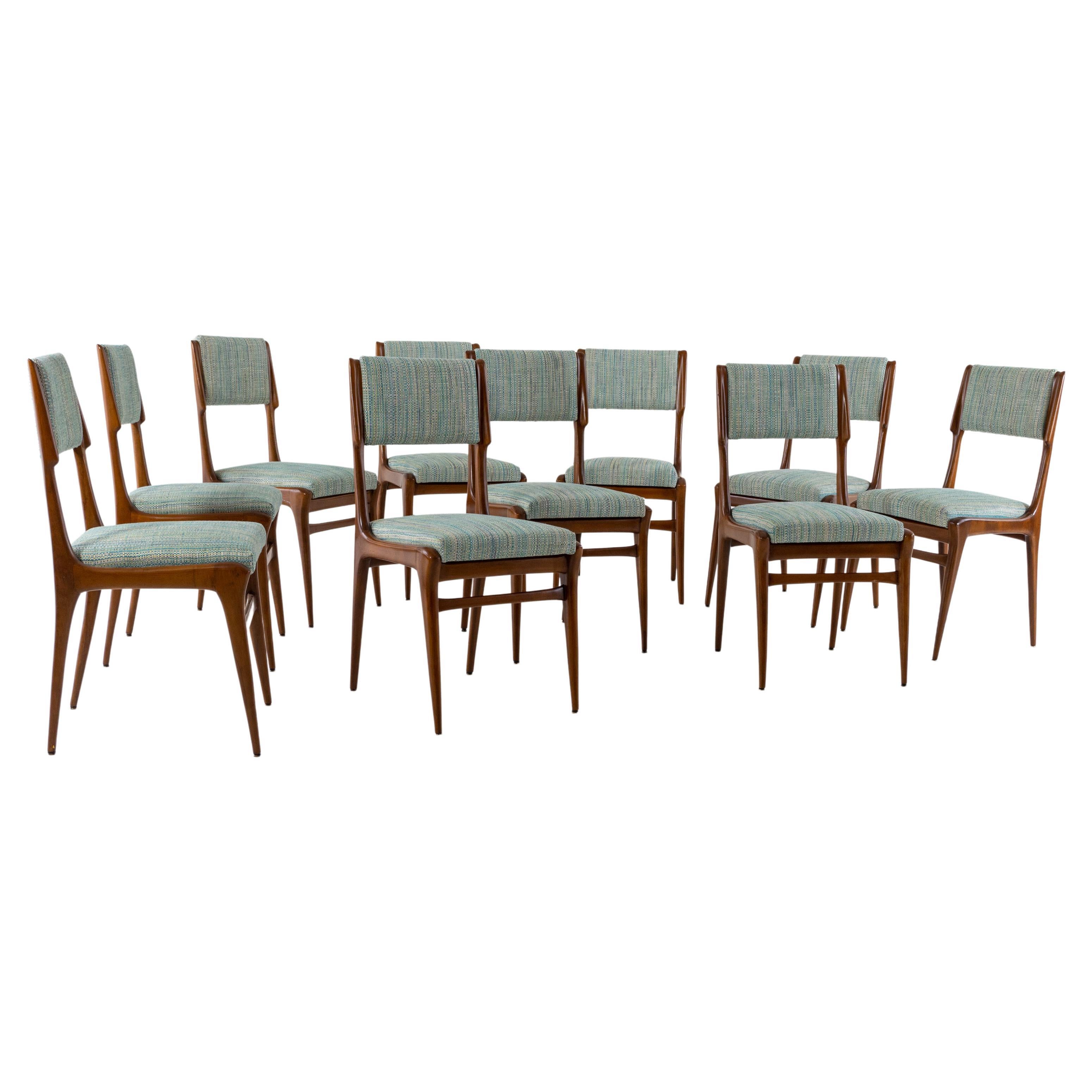 Set of ten dining chairs on elegant wooden frames with upholstered seats and backs. The chairs have been reupholstered in a light blue fabric and hand polished.
 