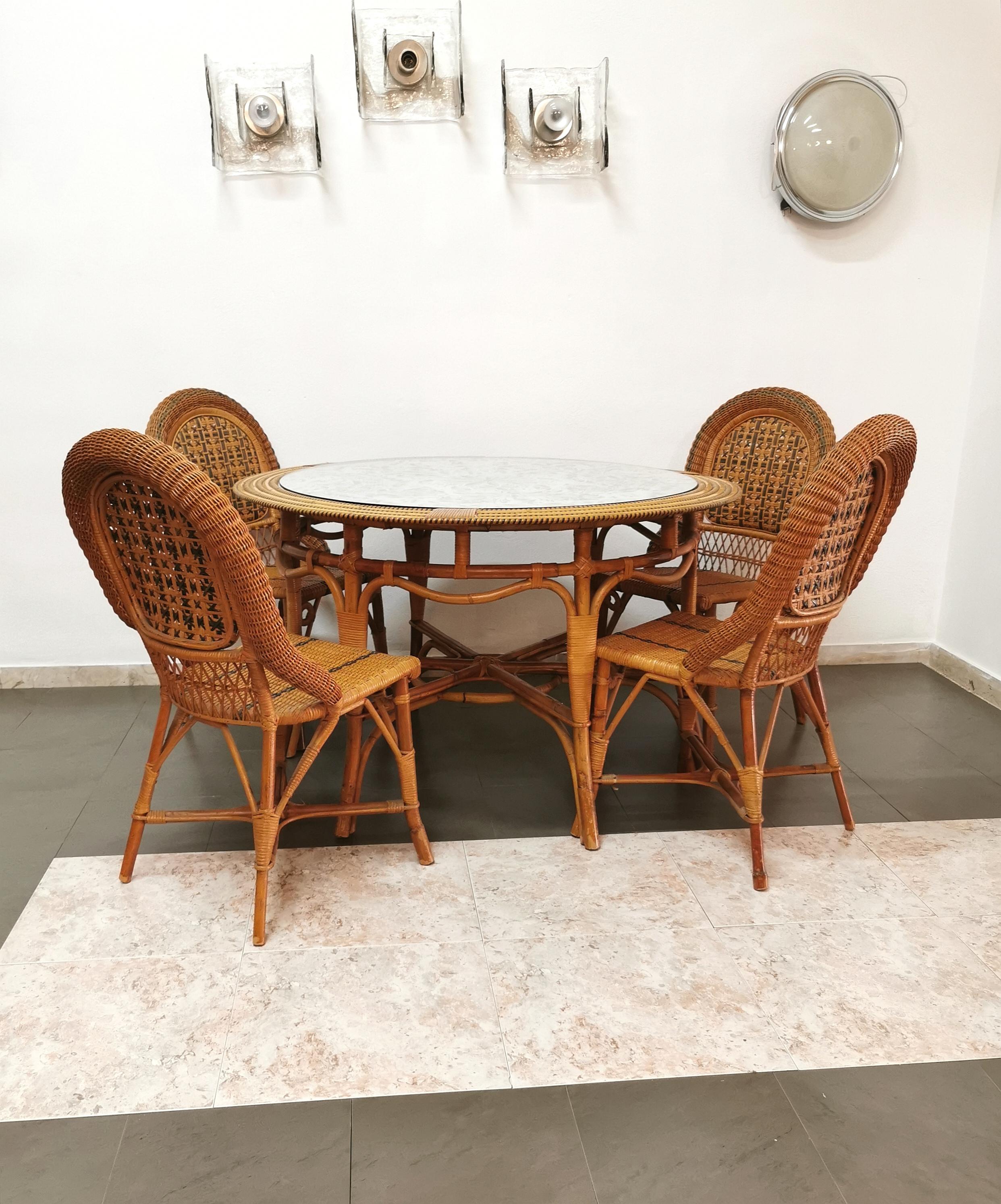 Coordinated set of 4 dining chairs and 1 table produced by Vivai del Sud in the 70s. The chairs were made of bamboo and rattan with particular green weaves. The circular table has a bamboo and rattan structure with a floral patterned fabric top by