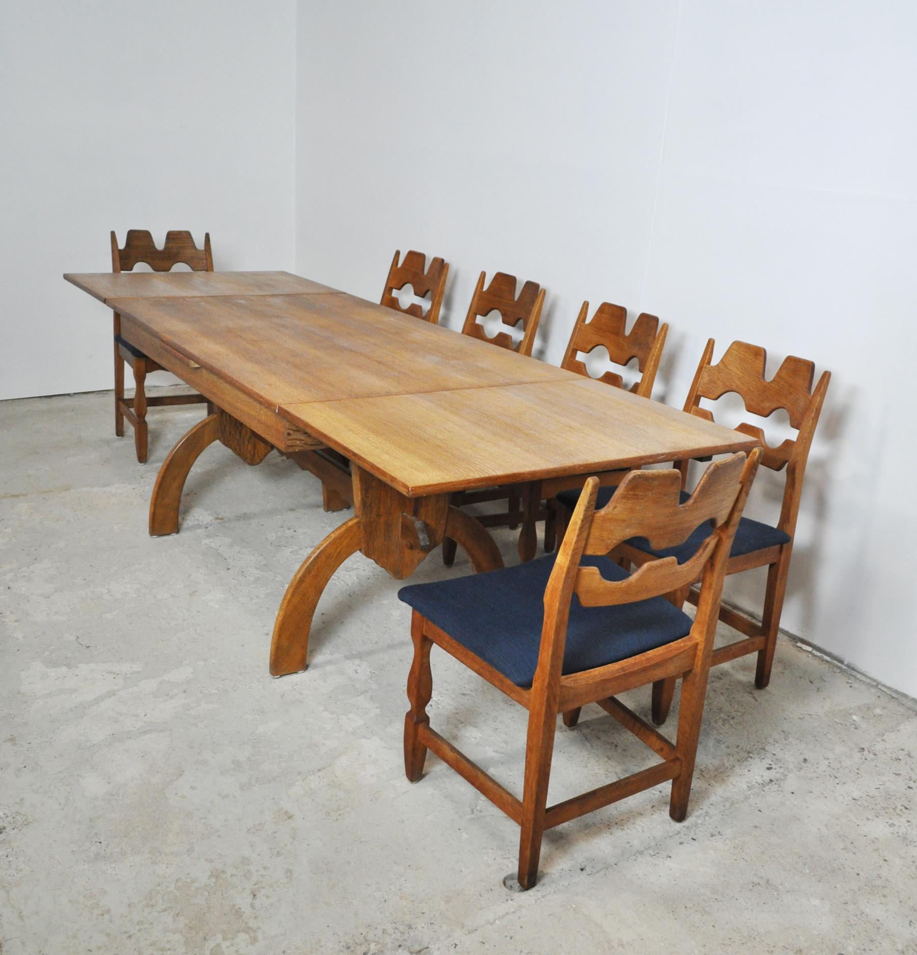 Dining room set designed by Henning Kjærnulf for EG Kvalitetsmøbel, made of solid oak and veneer. Table with a gorgeous grain and two expandable leaves. 6 dining chairs made of solid oak and new upholstery with dark blue wool fabric.
12 dining