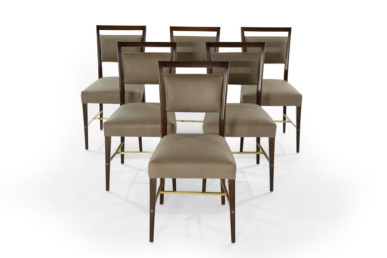 Nine piece dining set in mahogany, leather and brass designed by Paul McCobb for The Calvin Group, circa 1950-1959.
Features 6 side chairs and 2 armchairs with their signature brass stretchers. Fully restored and refinished. Newly upholstered in