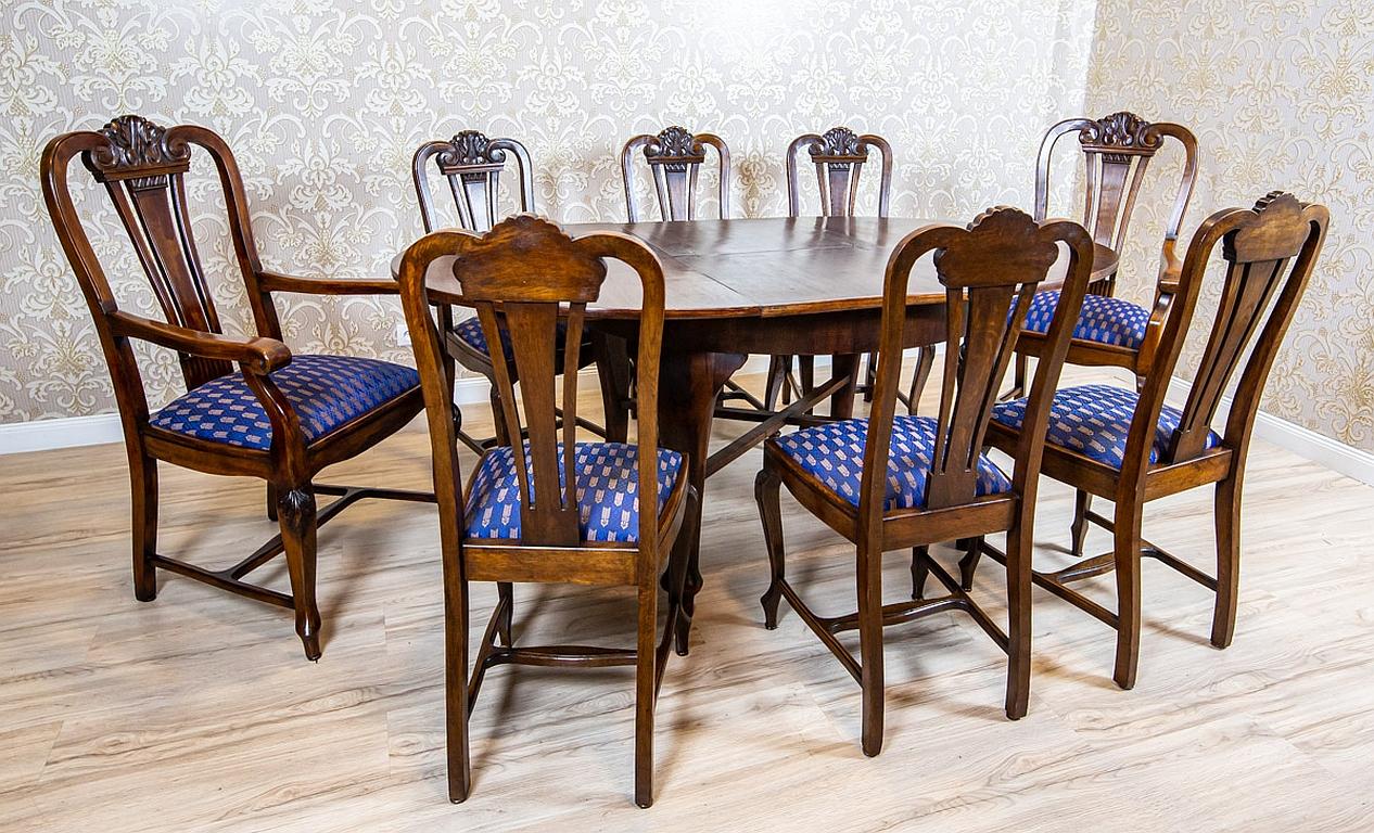 Esszimmergarnitur aus Eiche und Nussbaum aus der Zwischenkriegszeit, blau gepolstert

Der ovale Tisch mit einer Platte aus Walnusswurzelholz ist ausziehbar und für 8 Personen gedacht.
Die Stühle mit durchbrochenen Rückenlehnen sind mit geschnitzten