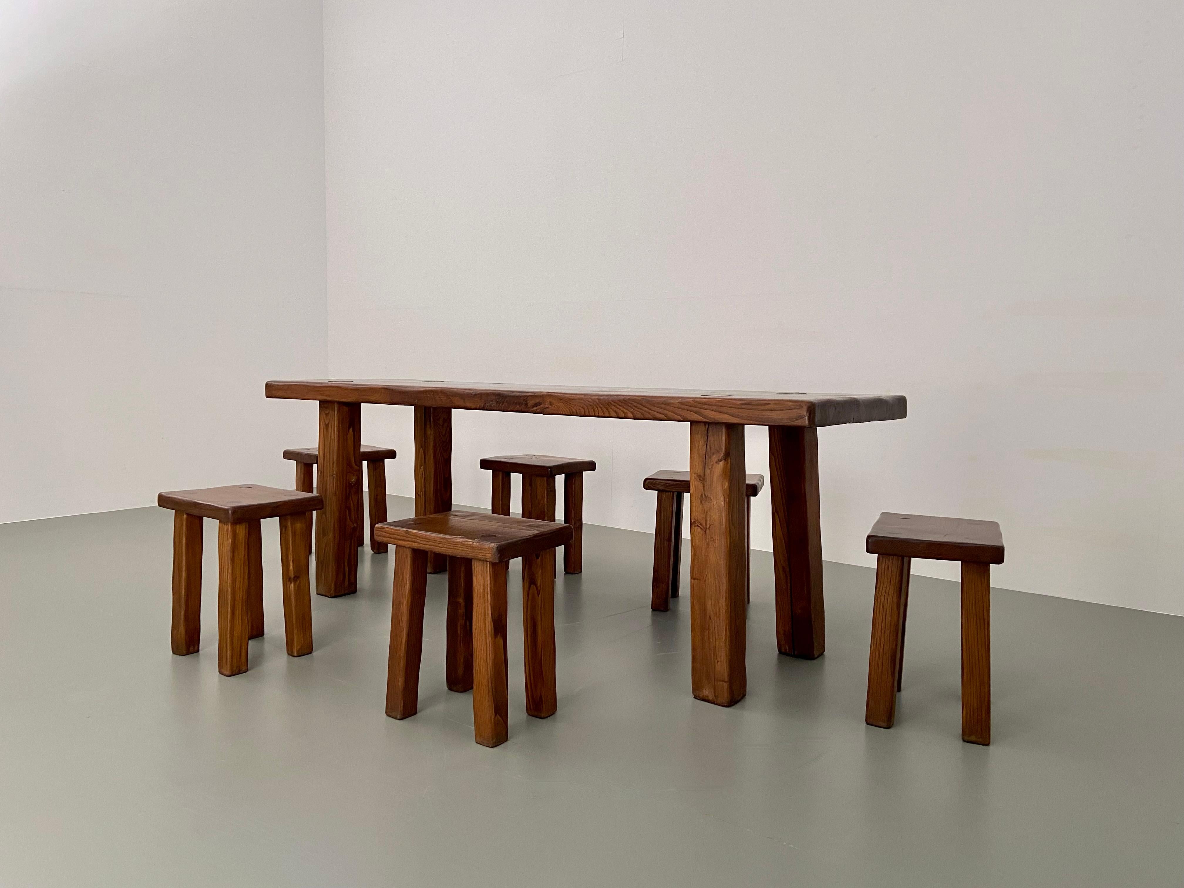 Very comfortable dining room table including six stools. The stools and table follow the same shapes creating a consistent and robust set. The table is made of solid elm and the top is quite thick and so are the squared legs, that are slightly out,
