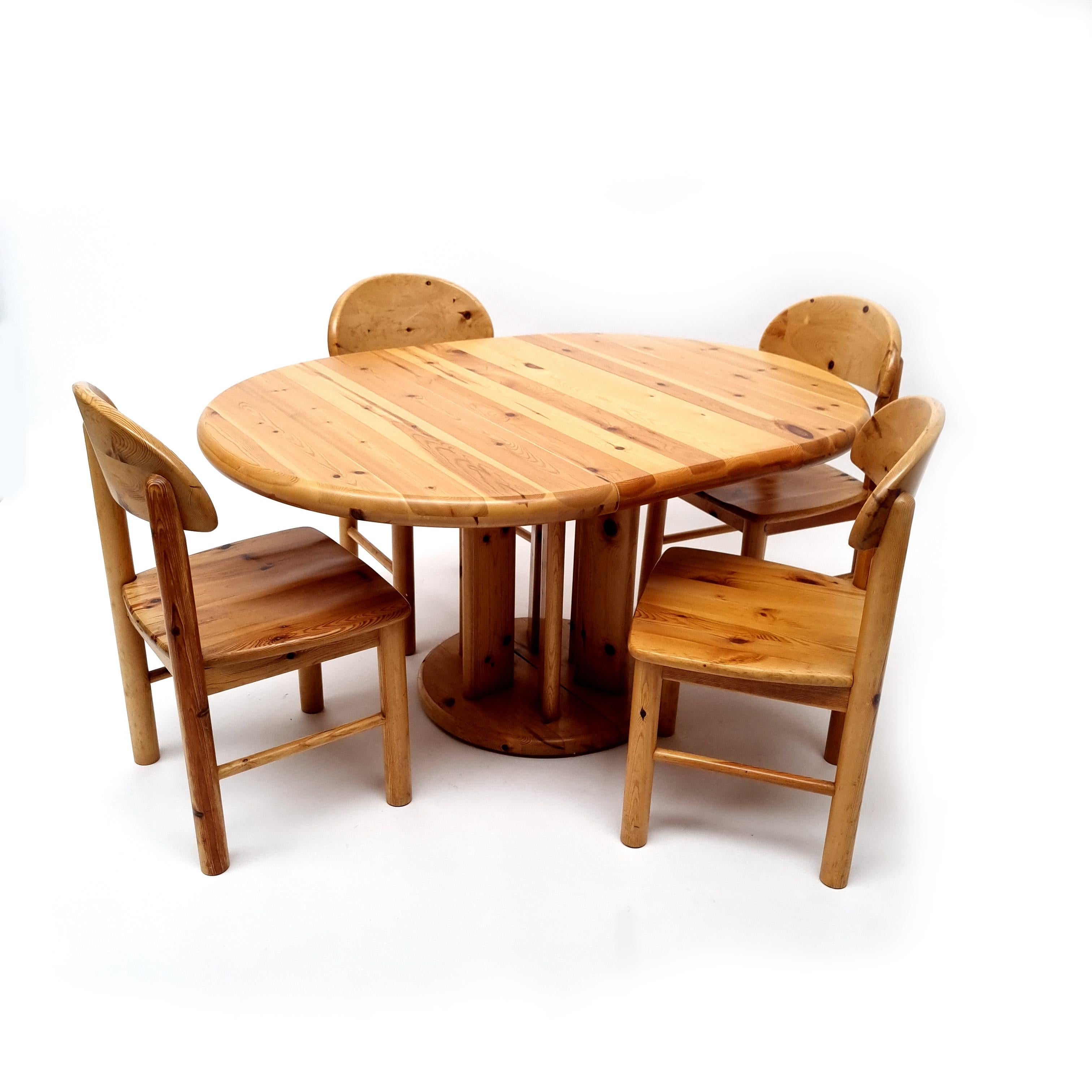 Pine dining set consisting 4 chairs and a pine table by Rainer Daumiller. Manufactured in Denmark, circa 1970. The table (with a 50cm extension!) is made in the highest quality solid pinewood and has gained a nice honey colored patina through the