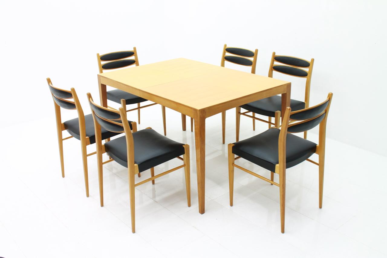 6 chairs in cherrywood and black leather and a dining table that can be extended. This set was purchased in 1957.

Measurements in cm. 
Table: D 89.5 cm, W 129 cm + 60 cm extension. H 74 cm
Chairs: H 82.5 cm, W 46 cm, T 50.5 cm, SH 46 cm

Good