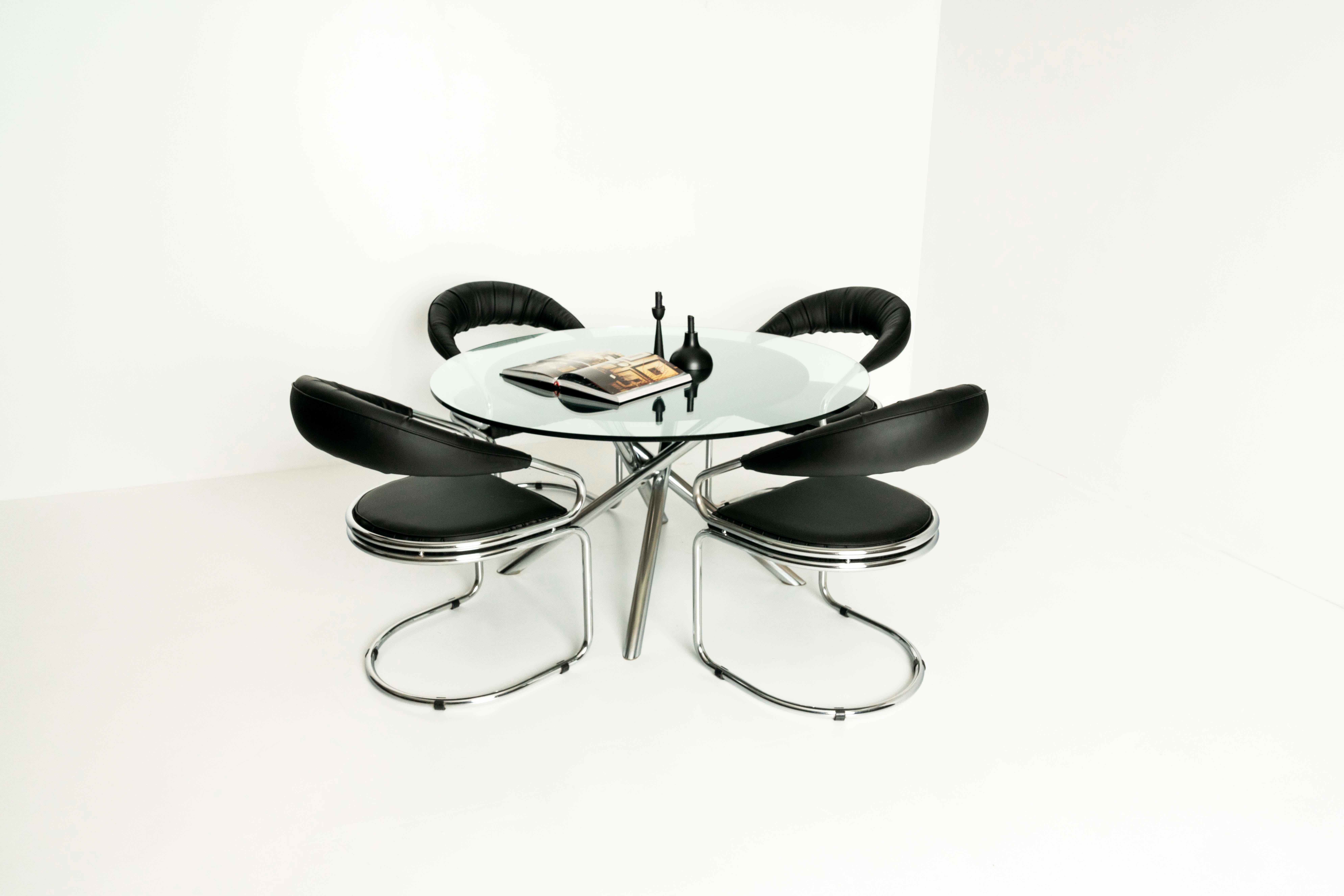 Very nice dining room set by Giotto Stoppino from the 1970s in Italy. This set consists of a dining table and four matching dining room chairs. The table has a tubular, chrome-plated metal base, a textile cover, and a glass top. It is in good