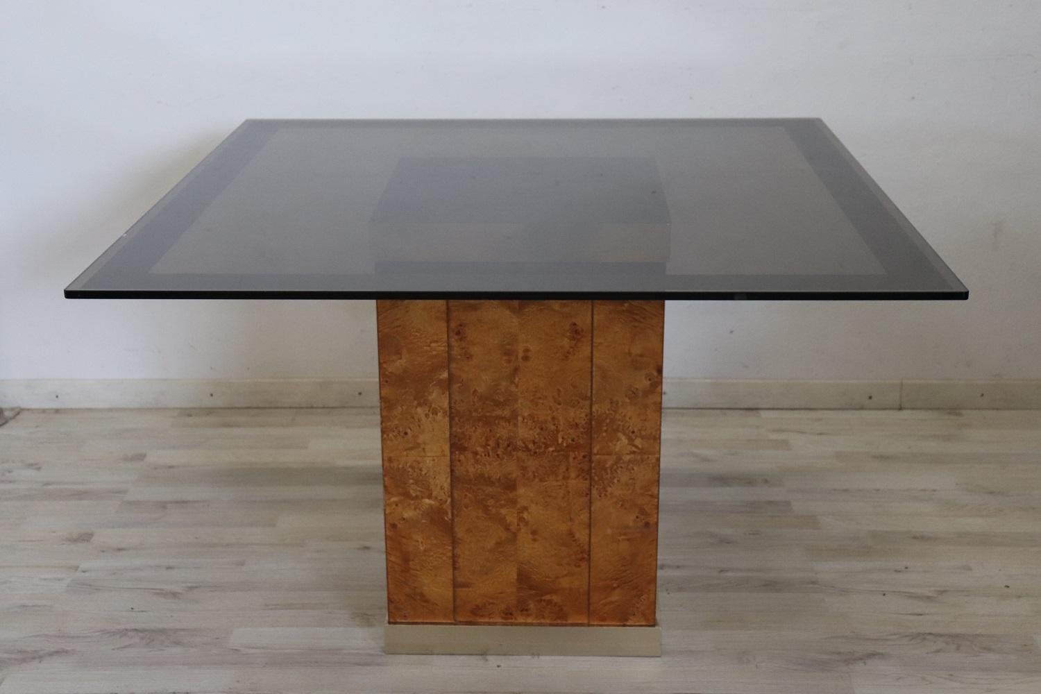 Rare and fine quality French design 1980s square luxury dining room table by Jean Claude Mahey for Roche Bobois. This fantastic table has a base in fine walnut root with golden metal details and a dark smoked glass top. There are some signs of wear