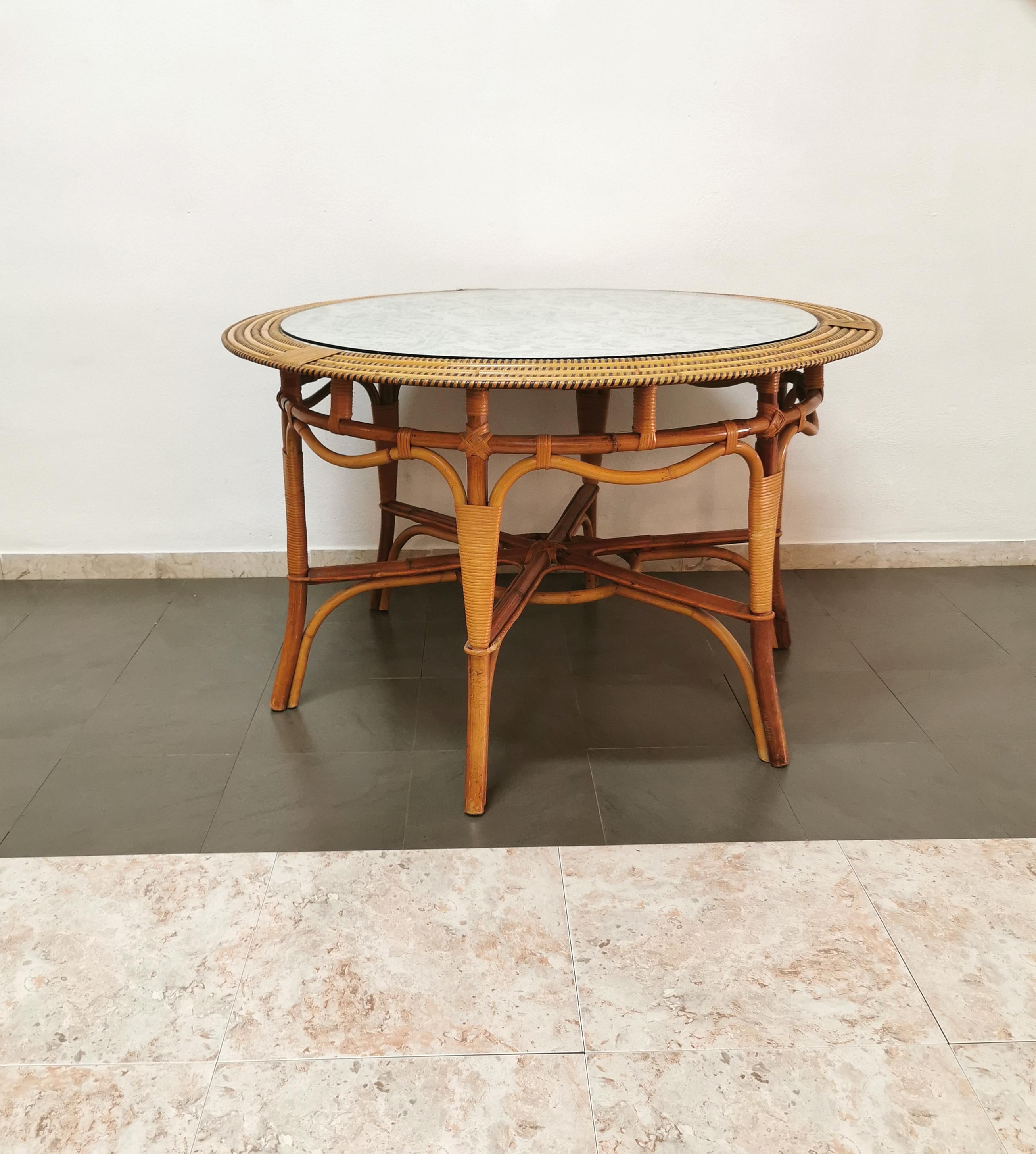 Dining or living room table produced in Italy in the 70s by the Vivai del sud company. The circular table was made of bamboo and rattan, with green weaves and a top in floral patterned fabric by the renowned Italian designer Valentino, where a