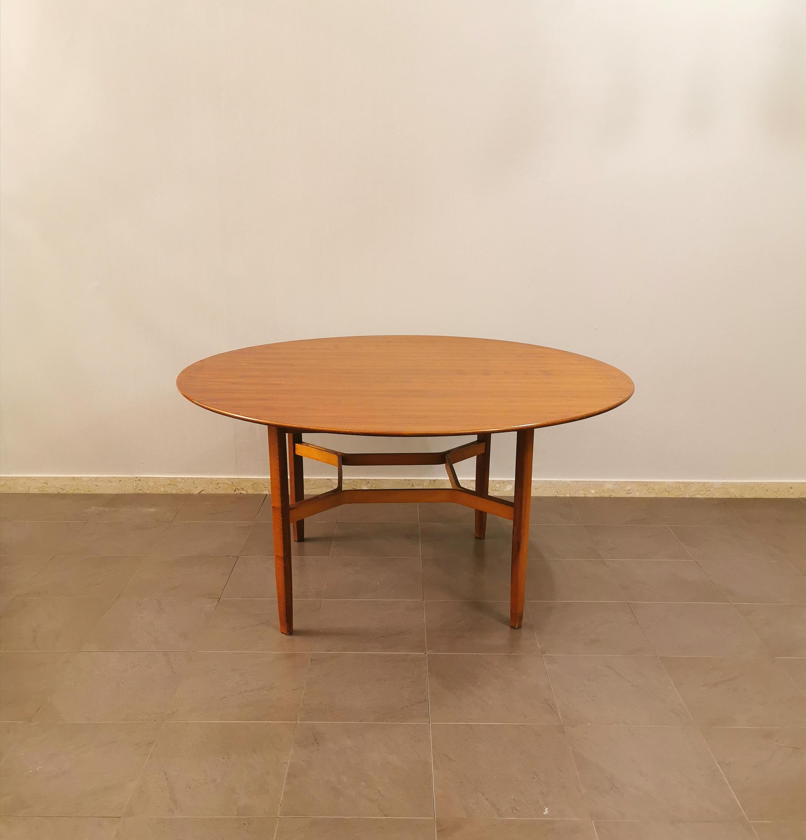 Dining table by the unknown designer in veneered wood with a round top resting on a quadripod structure. Italian production of the 60s.