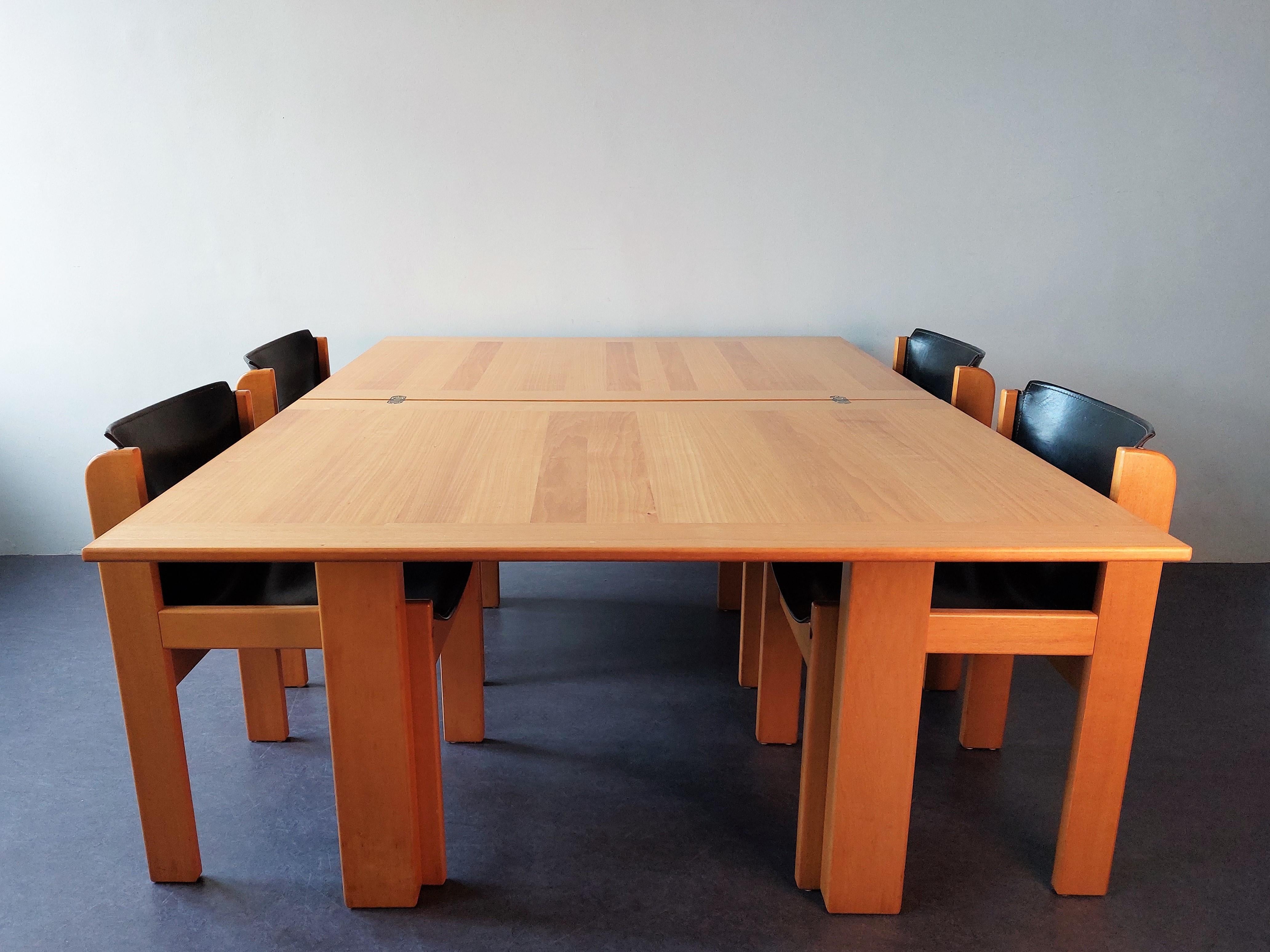 This dining set was made by the Italian manufacturer Ibisco in the 1970's. It has an extendable dining table and four chairs with black saddle leather seats. It is in a very good condition, with signs of age and use to mainly the top when