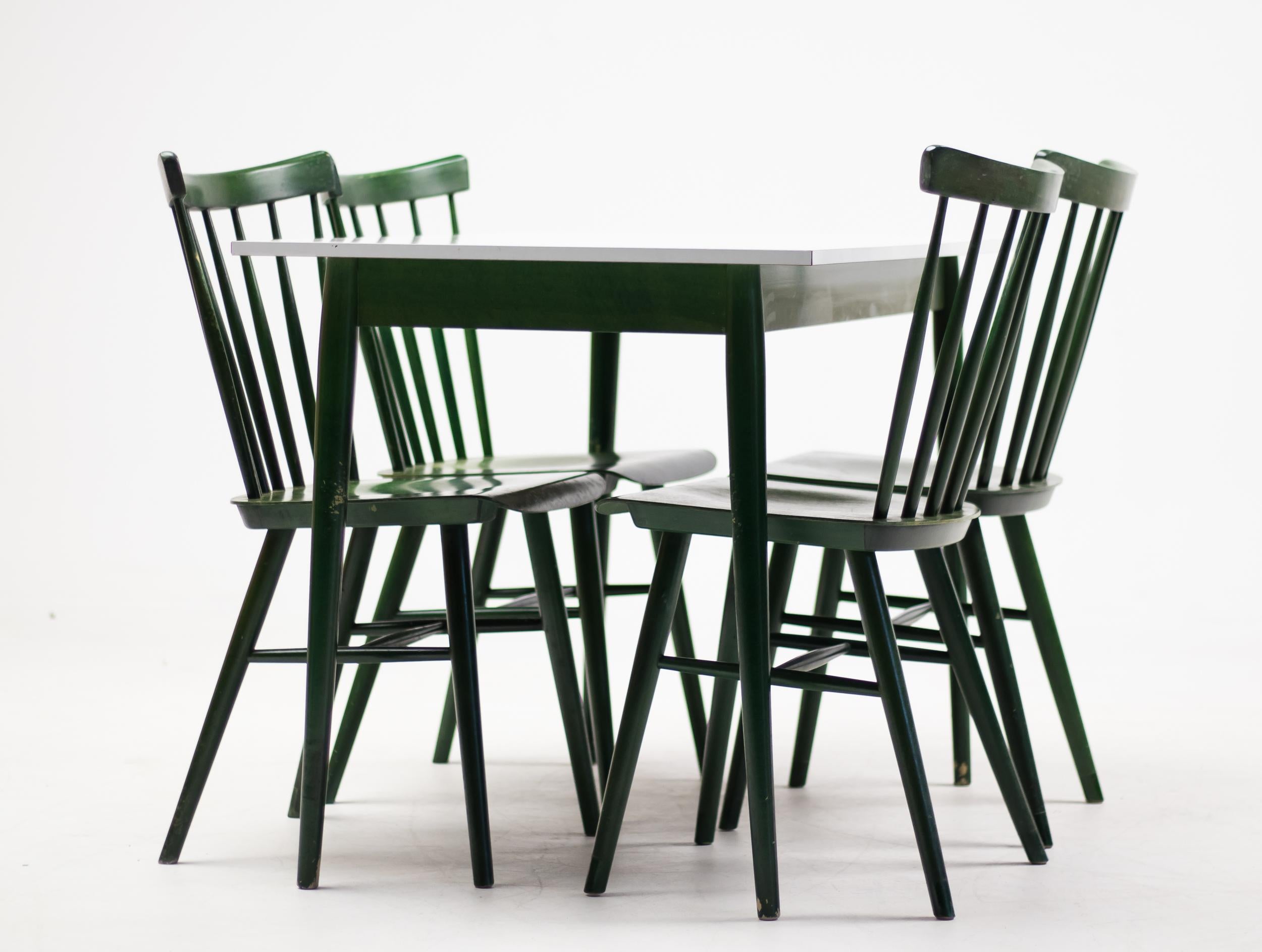 Dining set designed by Ilmari Tapiovaara in green dyed ash.
Four spindle back chairs with bent plywood seat with matching dining table with white laminated tabletop.
Chair with date stamp at the bottom of the seat.