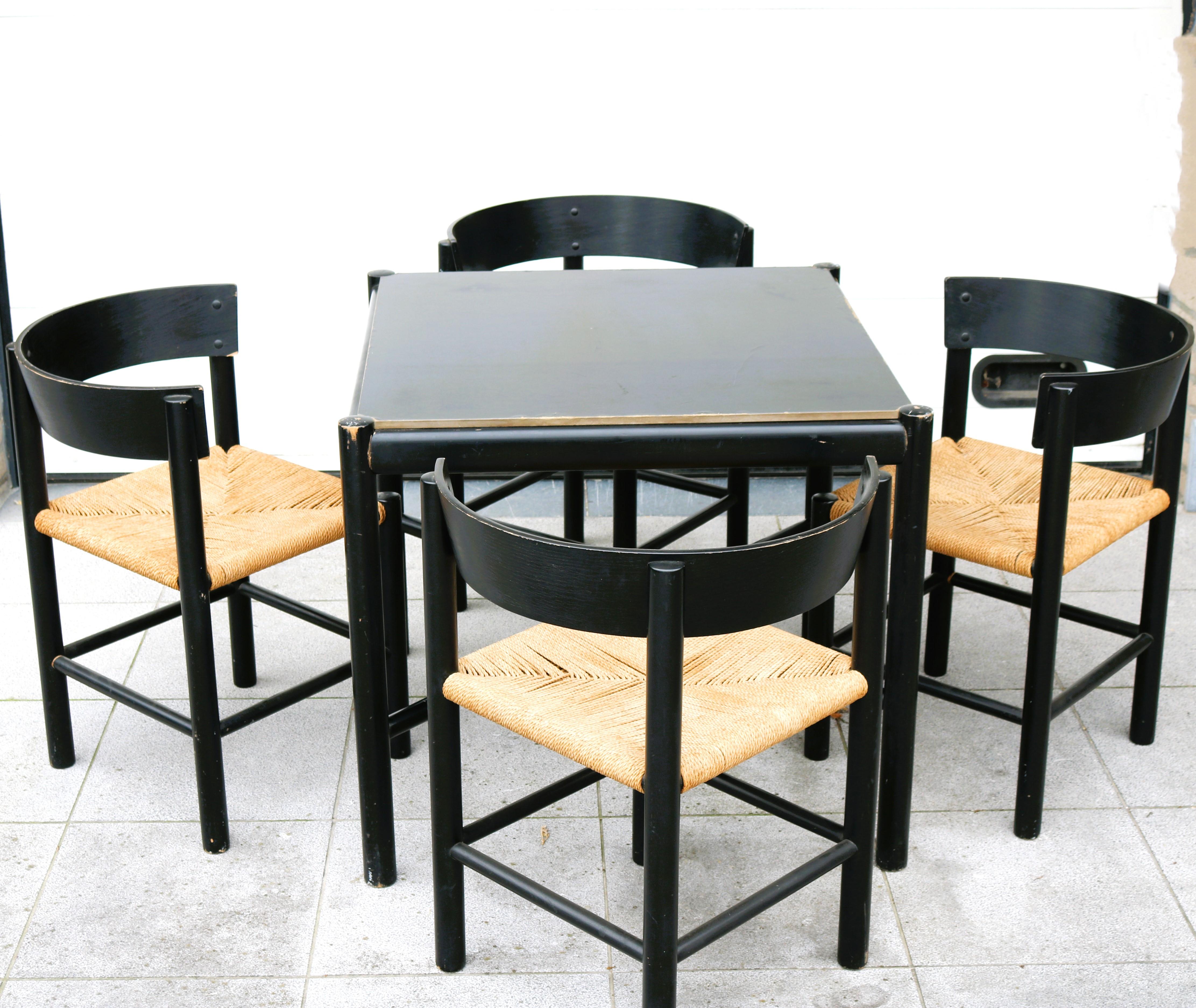 Set of four chairs and a table designed by Mogens Lassen for Fritz Hansen in 1964. Black lacquered wood and papercord, in original condition. The set is quite small, so it could fit in any room.The table is the model 4624 and the chair 4216.