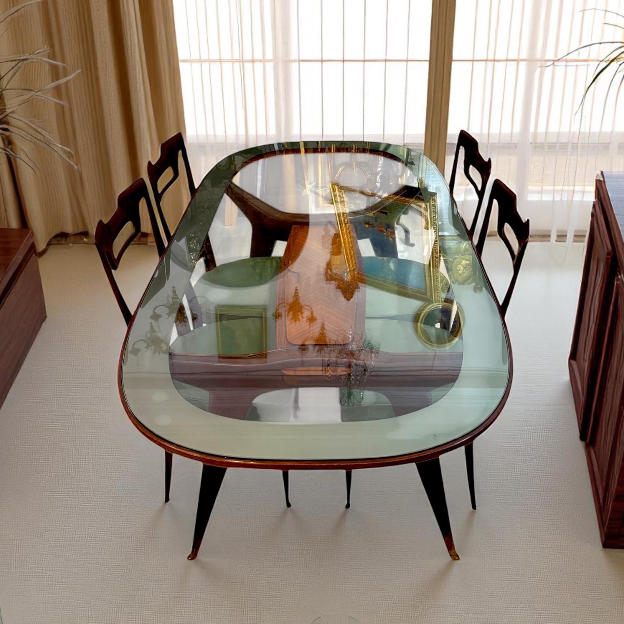 This dining set by Vittorio Dassi, dating from the 1950s, is a refined example of Italian mid-century modern design. The set includes a glass-top dining table paired with four sculptural chairs, all crafted with the designer’s signature attention to