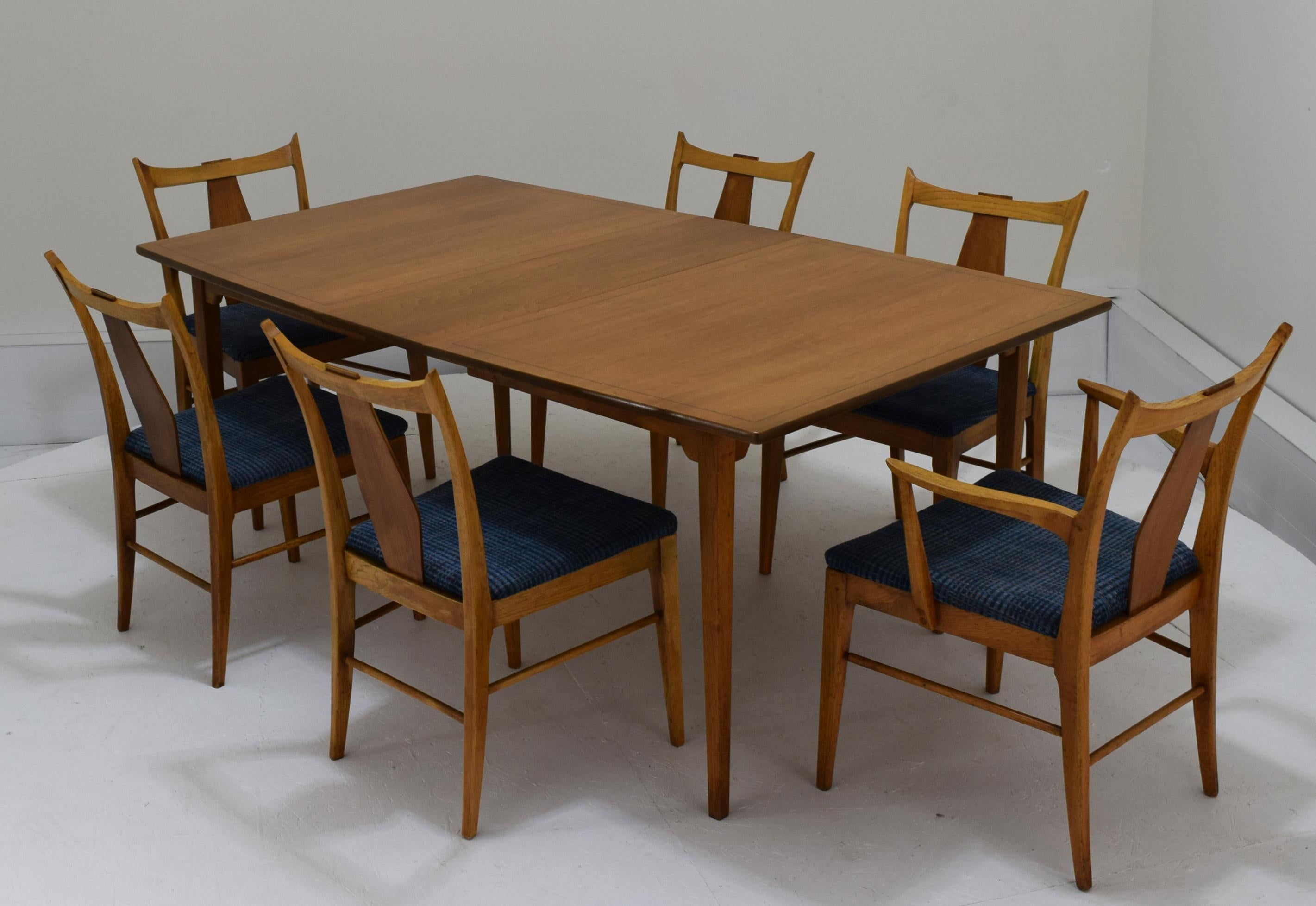 Produced by BF Huntley, circa 1950s. A charming suite with minute details combing subtle arts and crafts elements to an American modernist approach. Subtle flaring of the table top with an ebony insert running along the border, chairs with all edges
