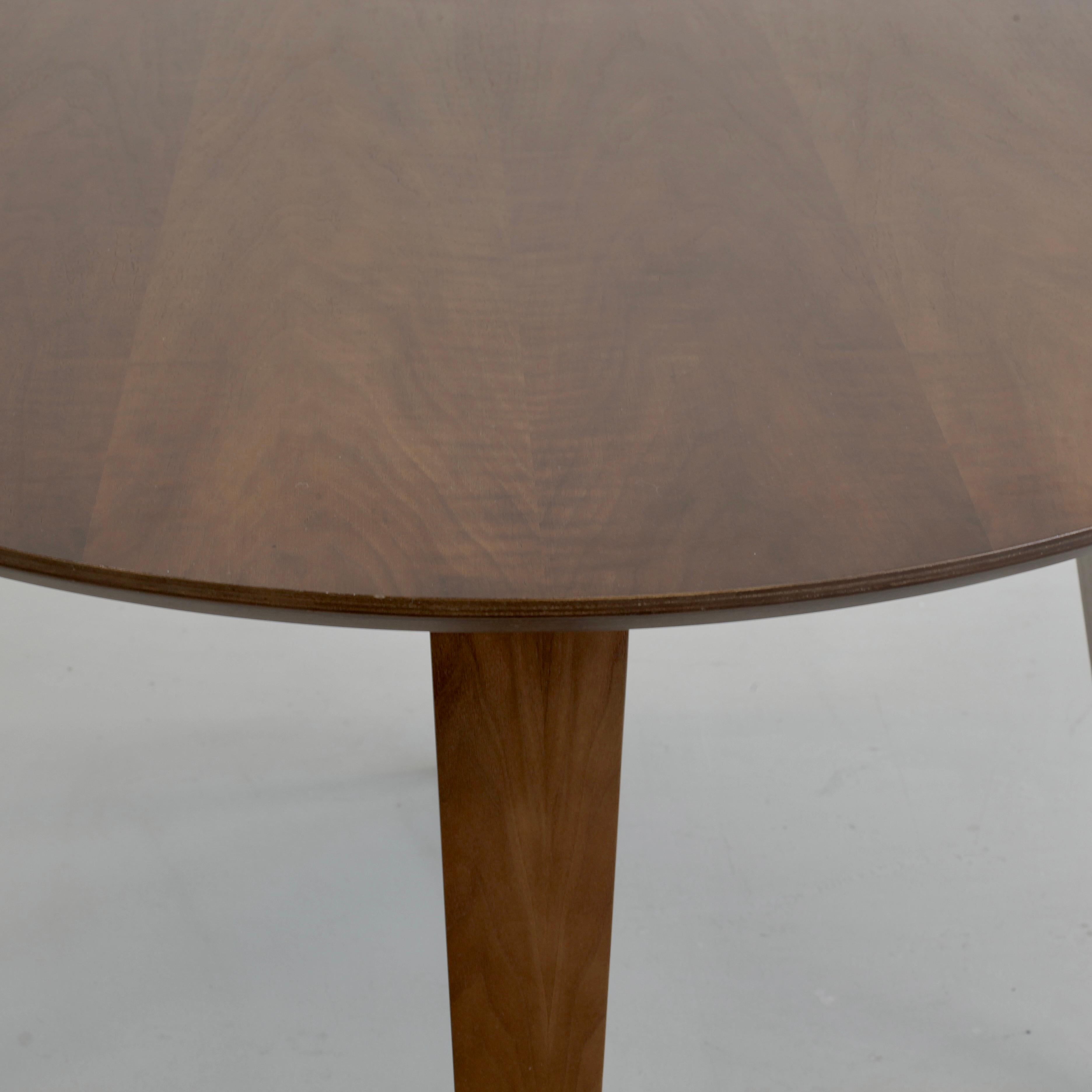 Round dining table designed by Benjamin Cherner. U.S.A., Cherner, 2003.

The top is made of cross-ply plywood featuring classic walnut veneer with a tapered profiled exposed edge. The legs are moulded laminated wood with exposed ply and hardwood