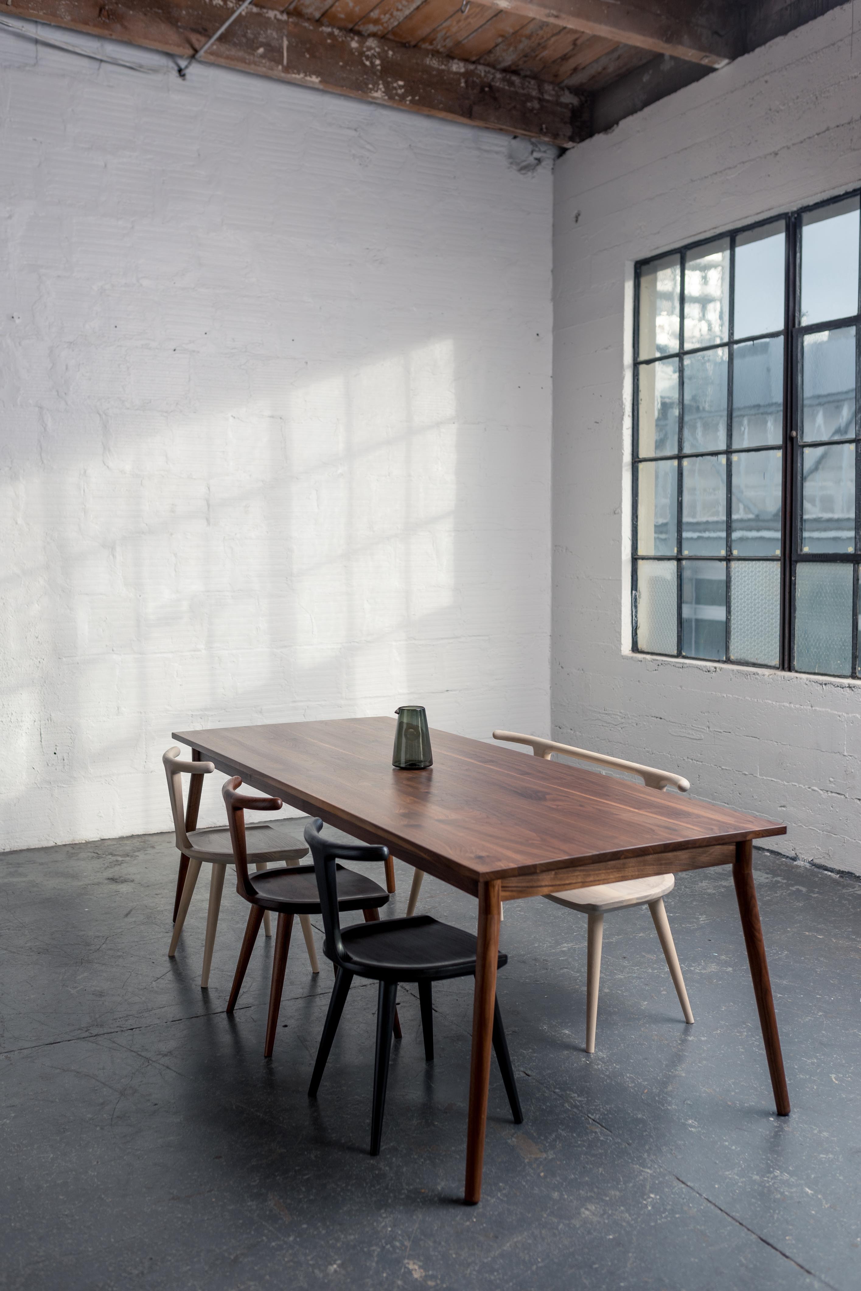 Une belle option minimaliste pour votre cuisine ou votre salle à manger. Fabriquée en noyer massif, cette table de salle à manger donnera à votre espace une impression de légèreté et d'ouverture, grâce à ses pieds légèrement tournés vers l'extérieur