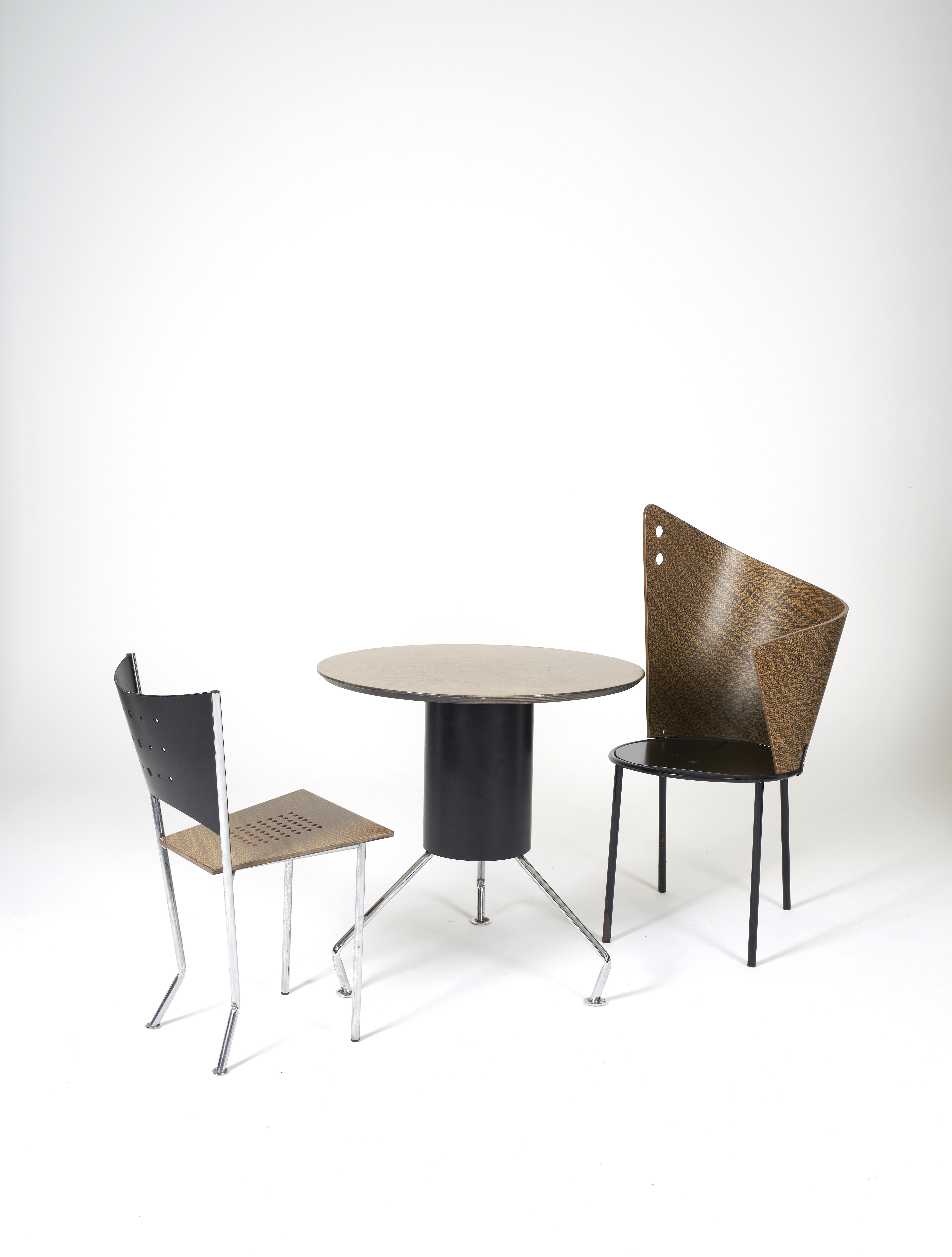 Set of a table and its two chairs 90s. Seats and backs of the chairs, table top in multi-ply wood and tubular steel structure in chrome or black lacquer. Sculptural and radical form for this unique set. Nice condition with some traces of use.