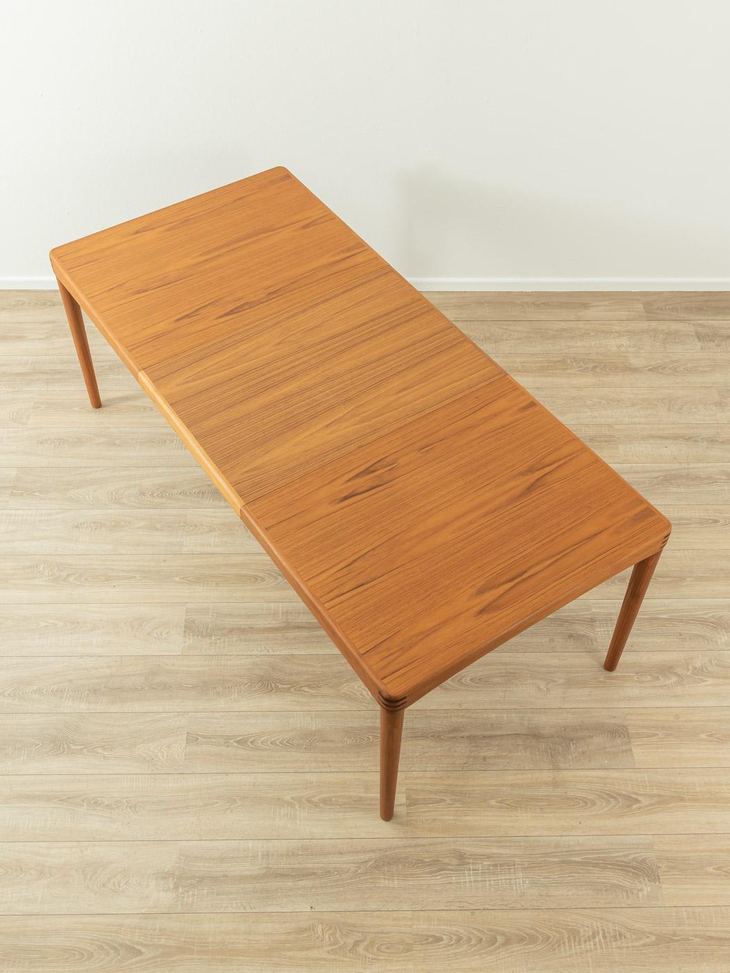 Classic teak dining table from the 1960s by H.W. Klein for Bramin. Solid frame and veneered table top with solid wood edge. The insert plate can be stowed under the table top
Quality Features:

 accomplished design: perfect proportions and