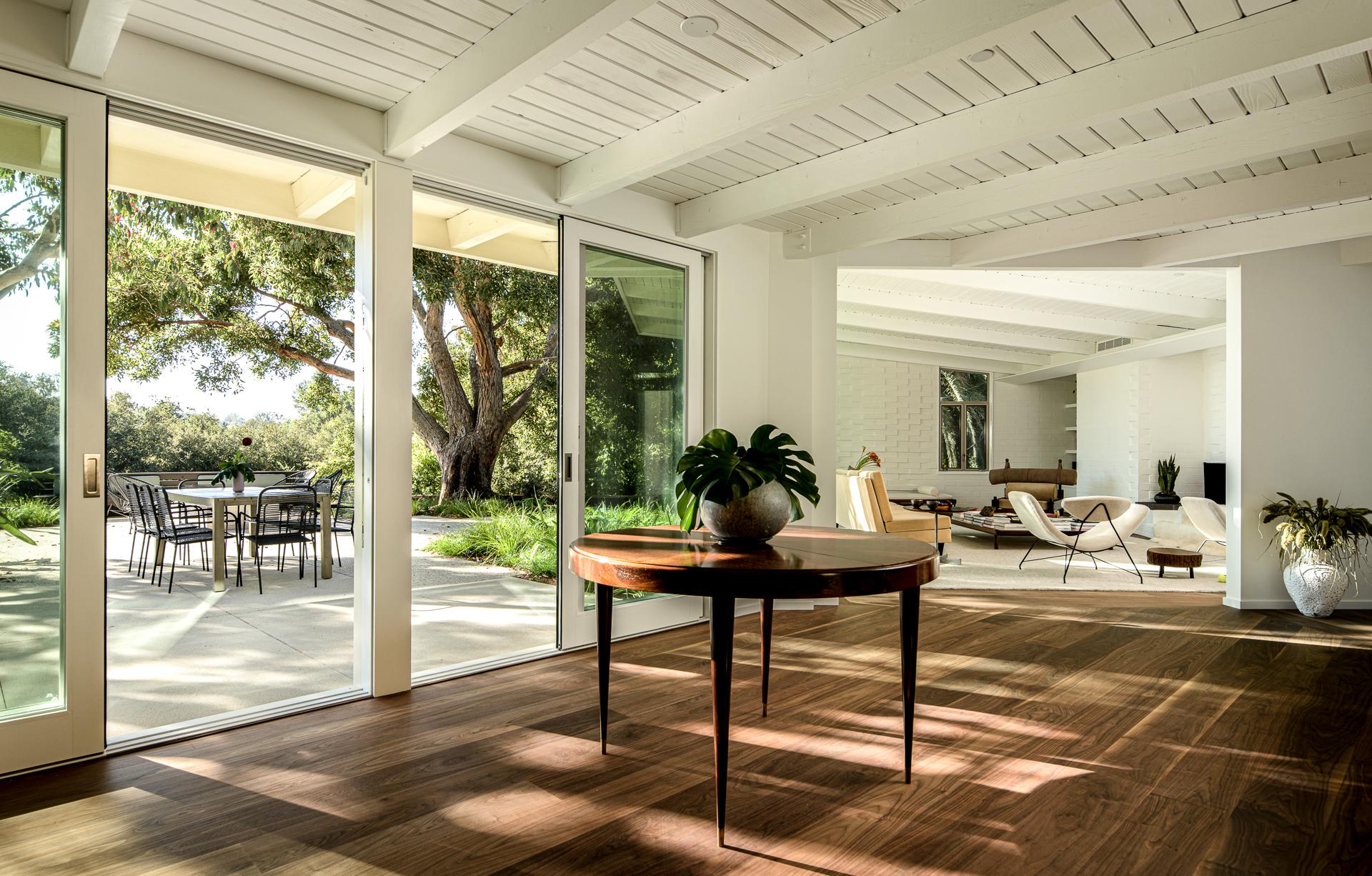 Exemple frappant de l'artisanat brésilien des années 1950, cette table de salle à manger ronde révèle la beauté expressive du palissandre jacarandá à travers son placage méticuleusement assorti. Le motif de grain rayonnant forme un soleil naturel