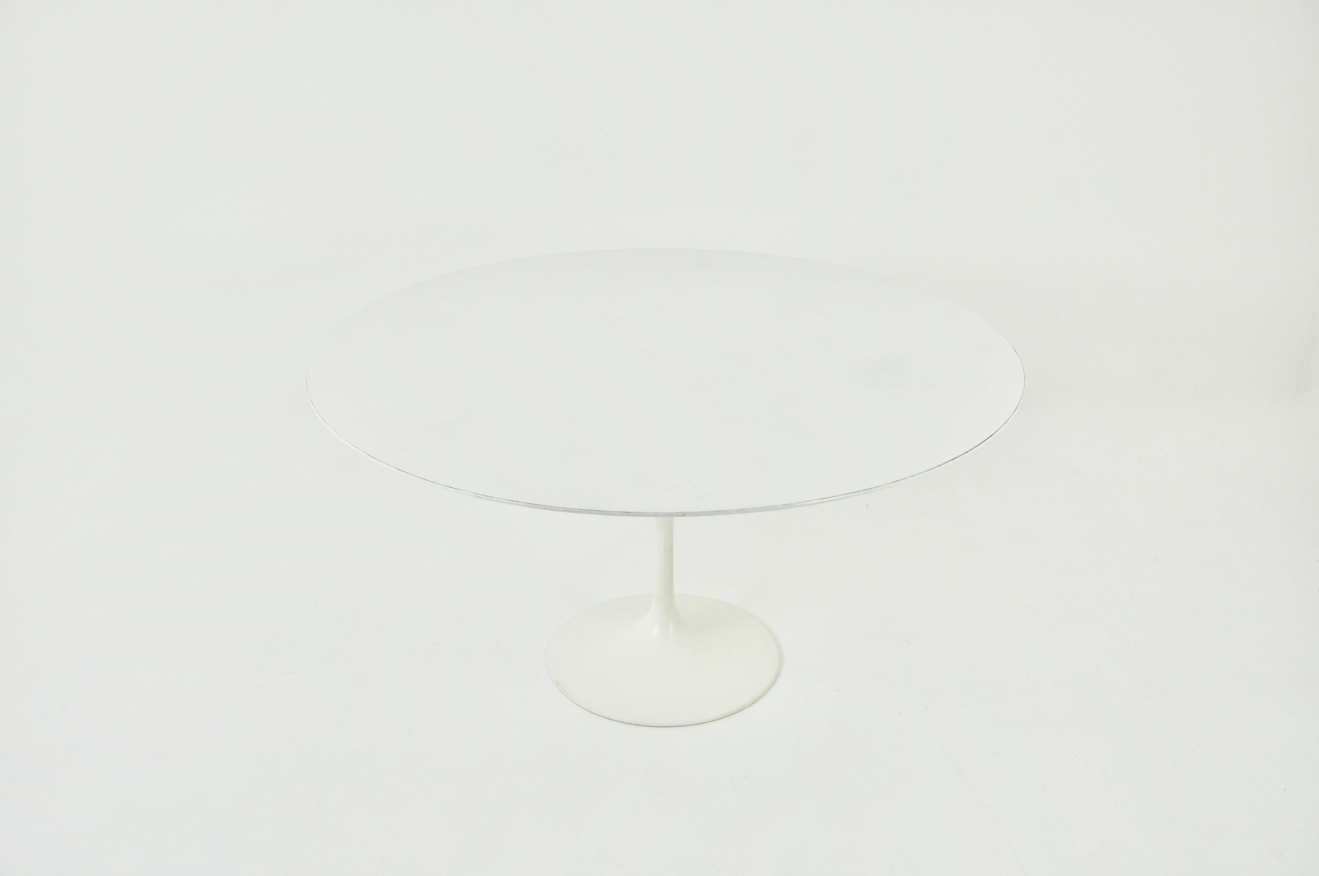 Round table in white laminated wood with aluminium base designed by Eero Saarinen and produced by Knoll International. Leg stamped Knoll International. Wear due to time and age of the table.